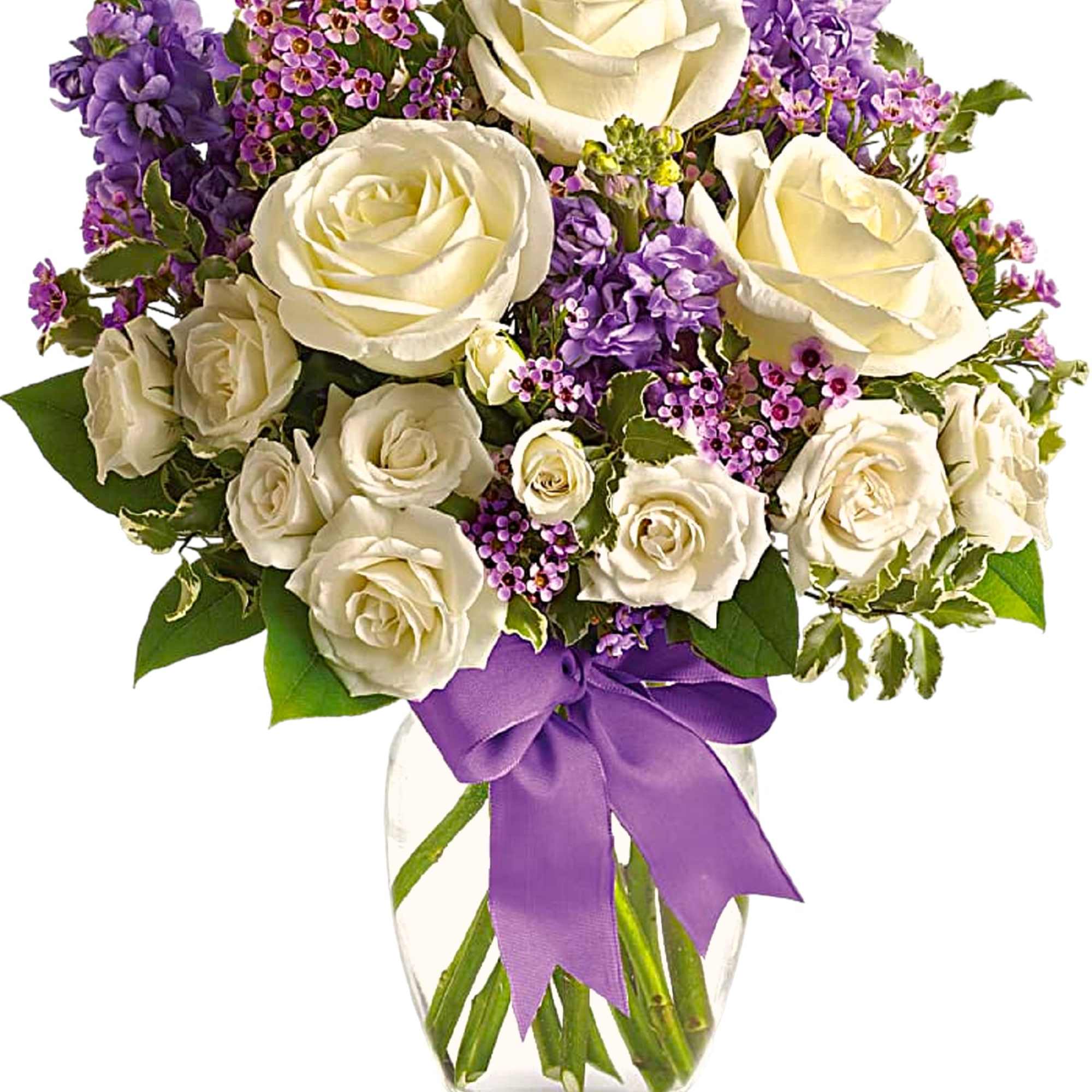 White roses and purple flowers in a clear glass vase with a purple ribbon