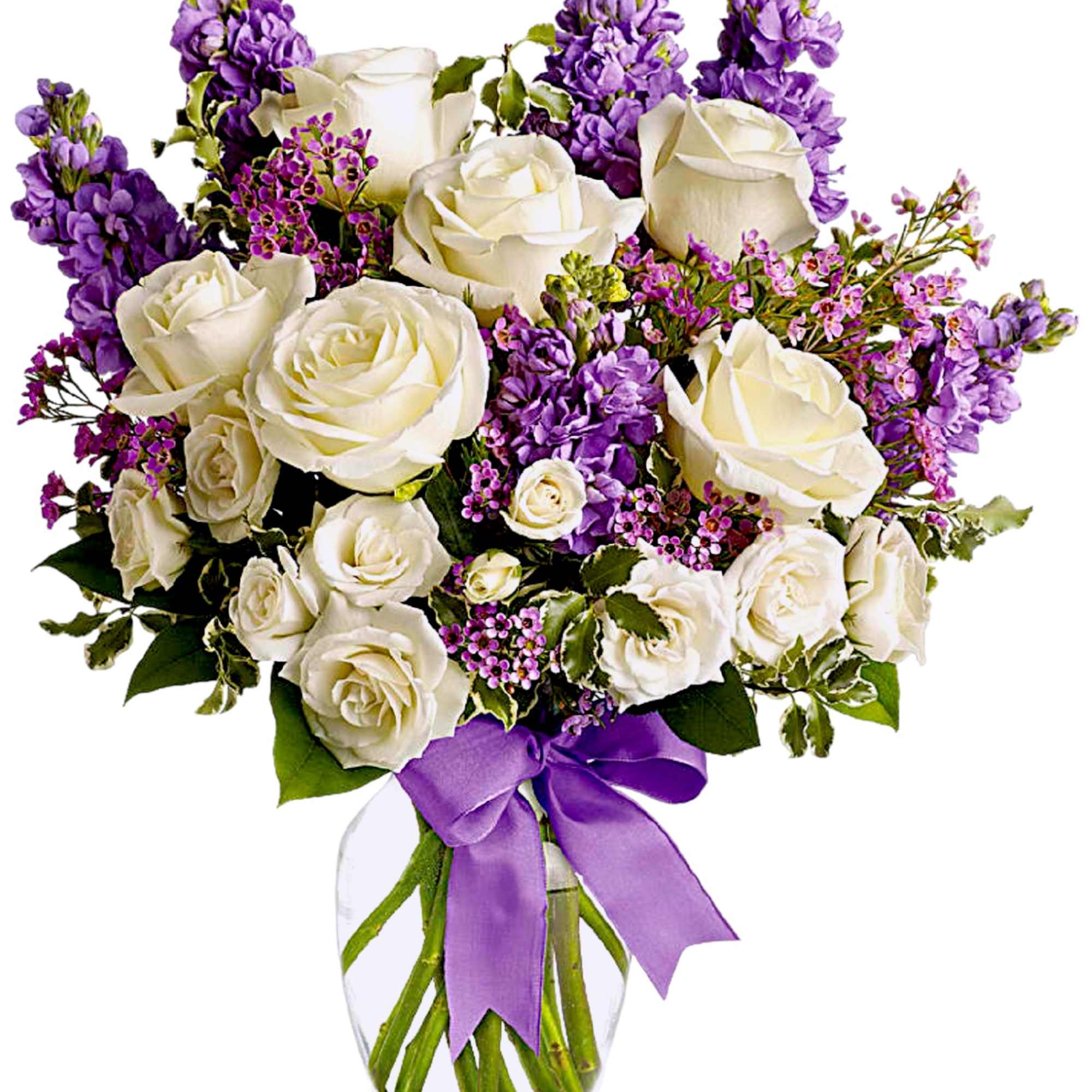 White roses and purple flowers arranged in a glass vase with a purple ribbon