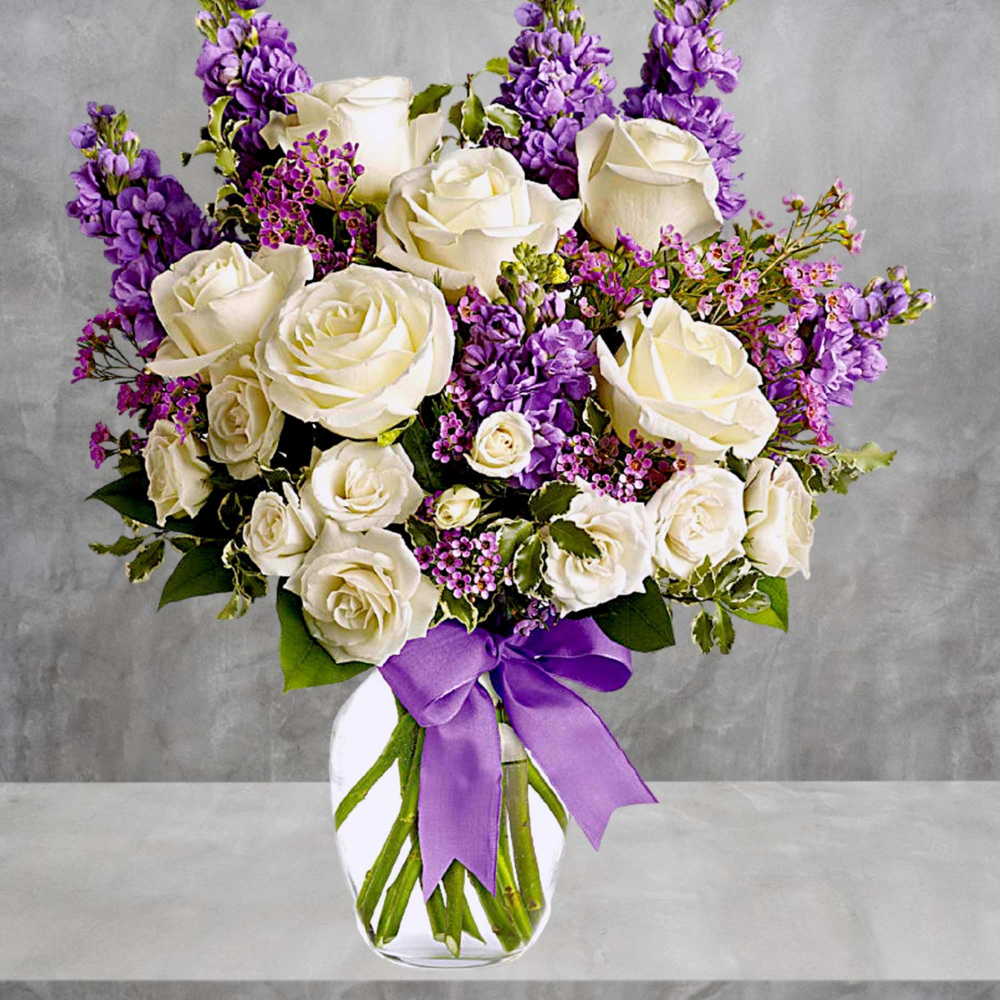 White roses and purple flowers arranged in a glass vase with a purple ribbon, photo 2 of 5