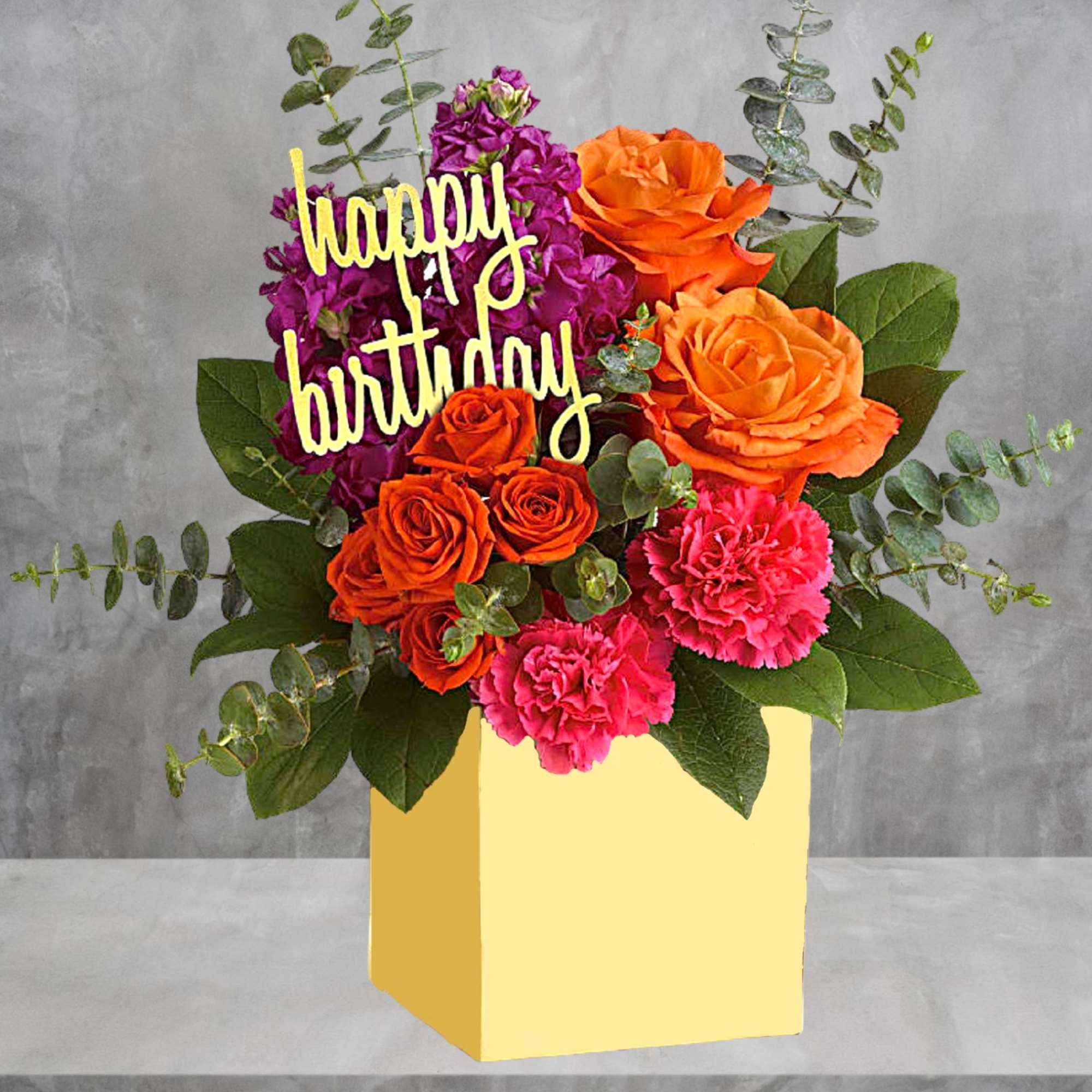 Bouquet of orange and pink flowers in a yellow box with a birthday sign