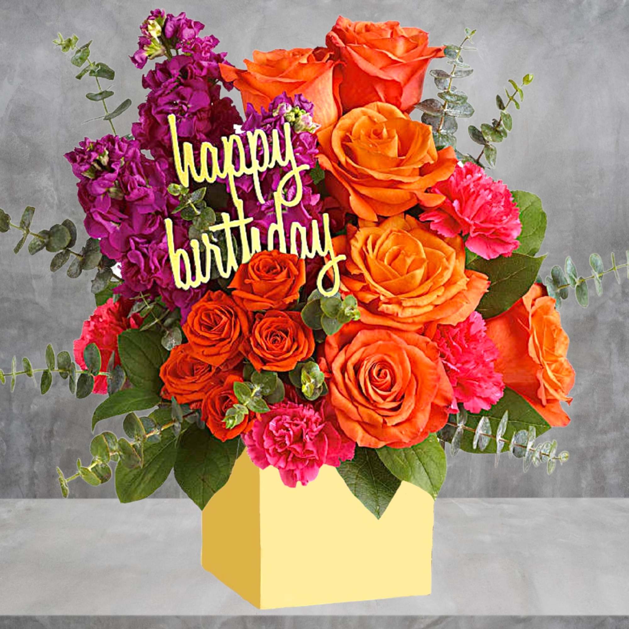 Orange and pink roses with a happy birthday sign in a yellow box
