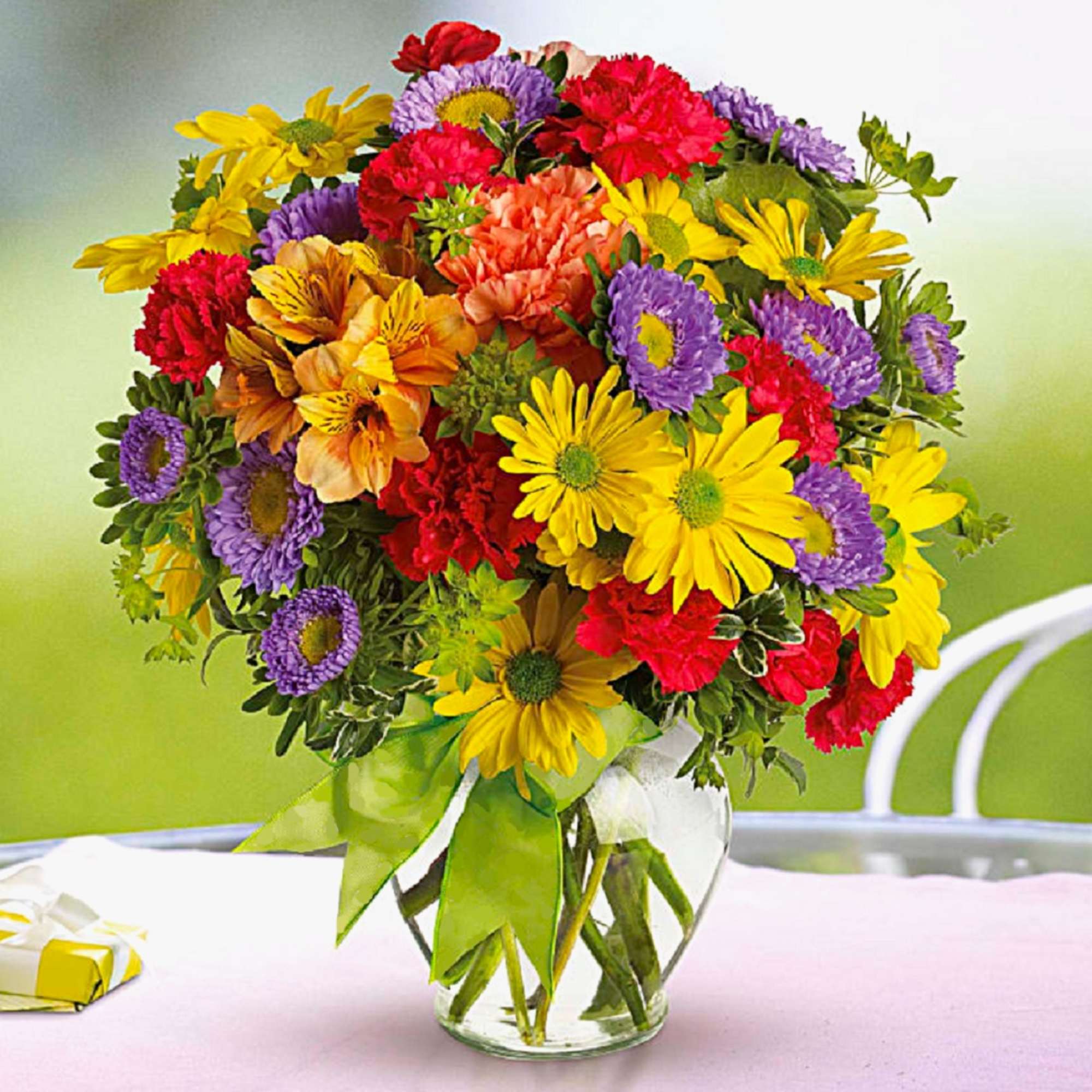 Colorful mixed bouquet in a clear glass vase with a ribbon