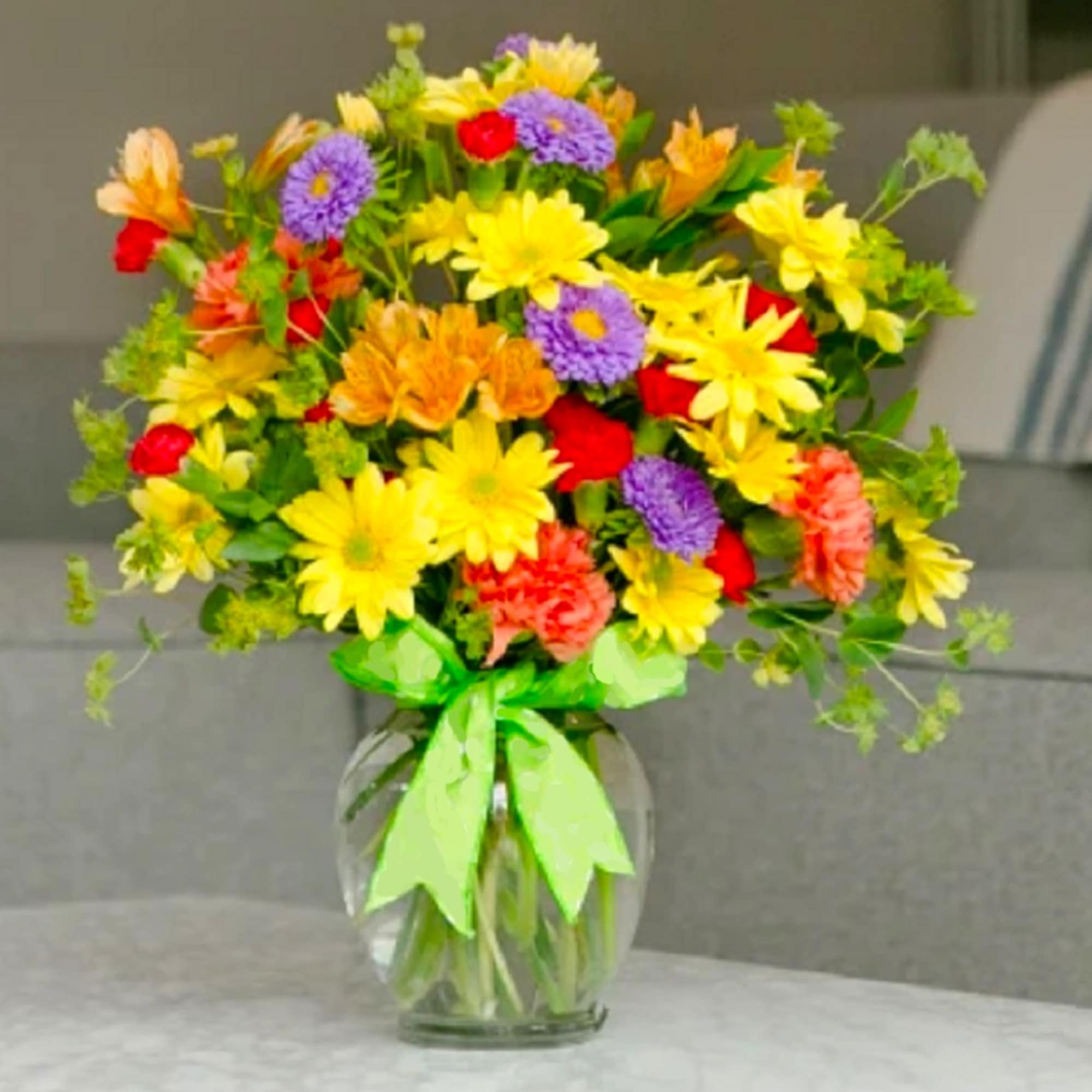 Colorful mixed bouquet in a clear glass vase with a green ribbon, photo 5 of 6