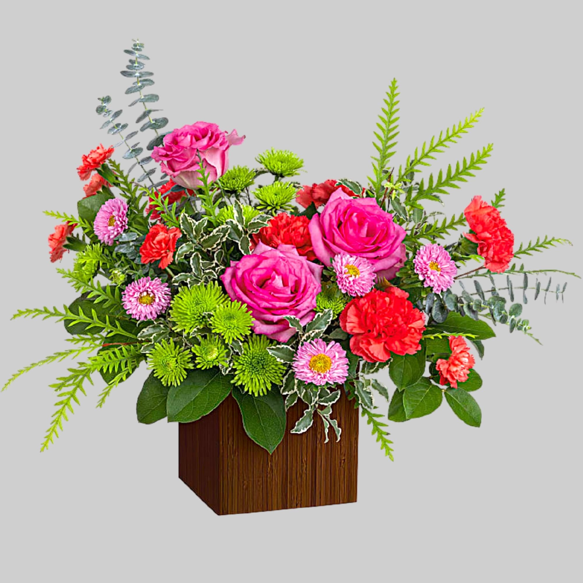 Pink roses and mixed flowers arranged in a wooden cube vase