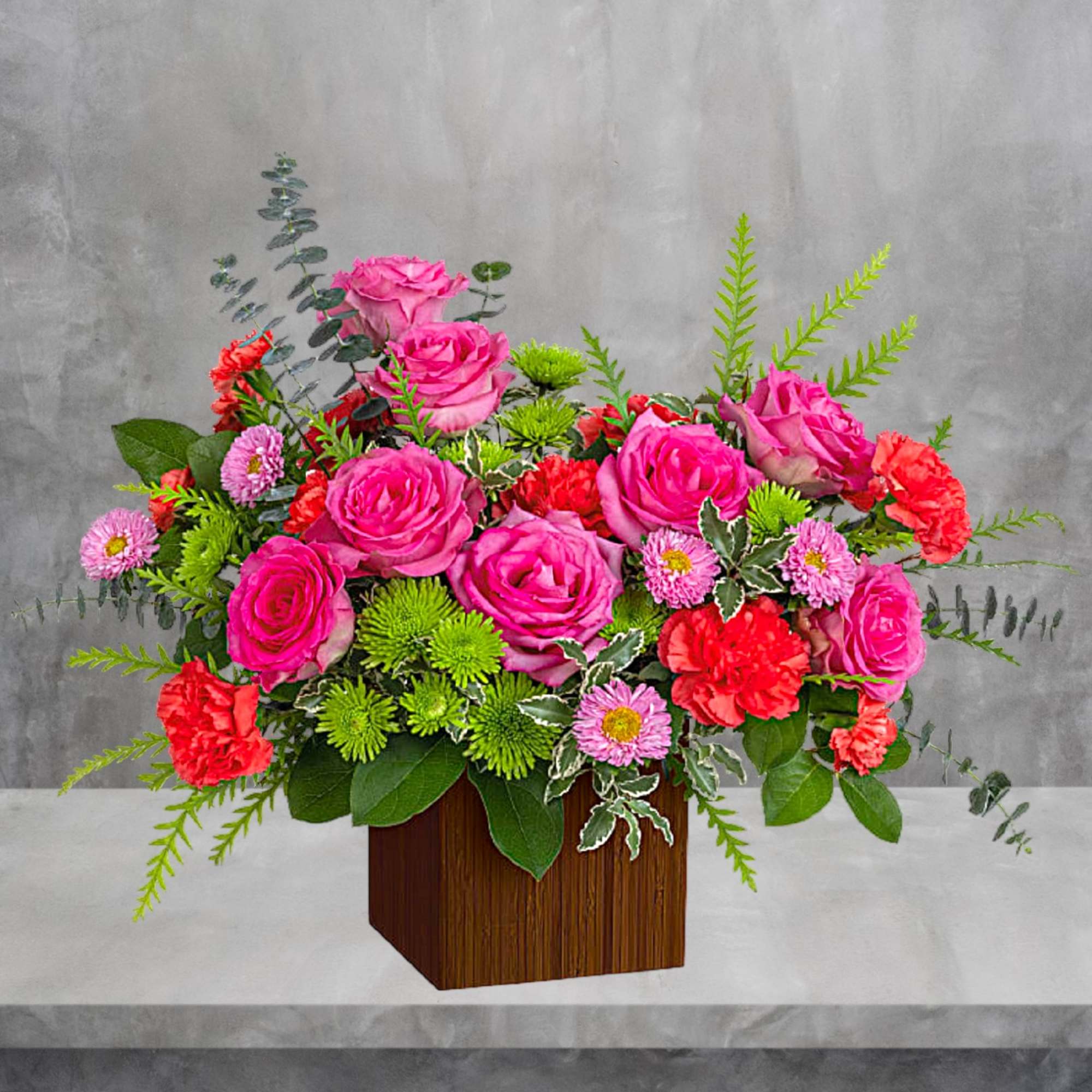Pink roses and red carnations arranged in a wooden box