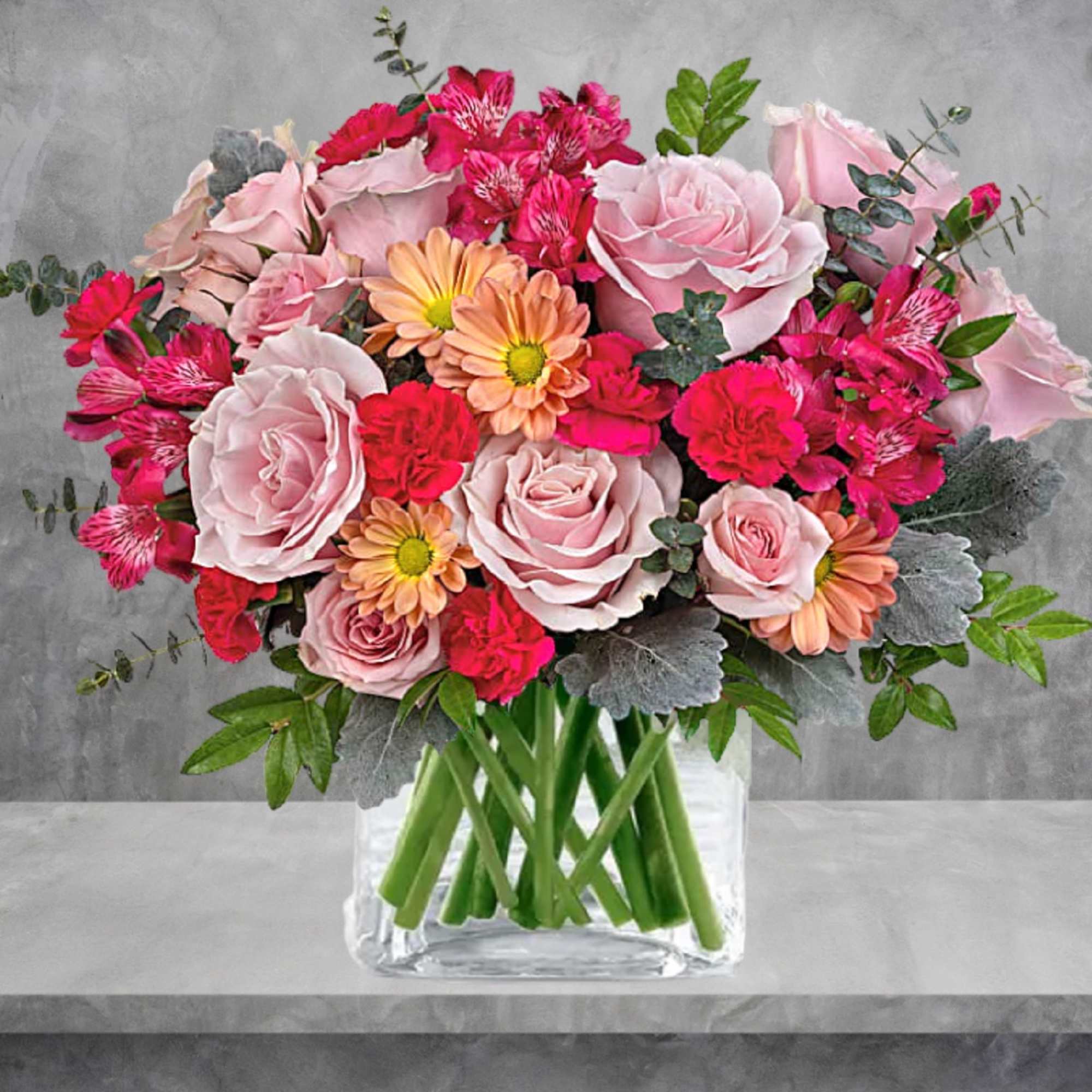Pink and peach mixed bouquet in a clear glass vase