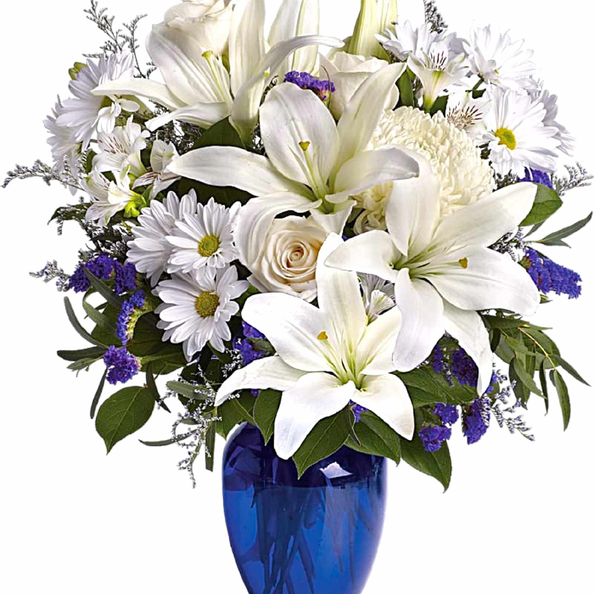White lilies and daisies arranged in a blue glass vase