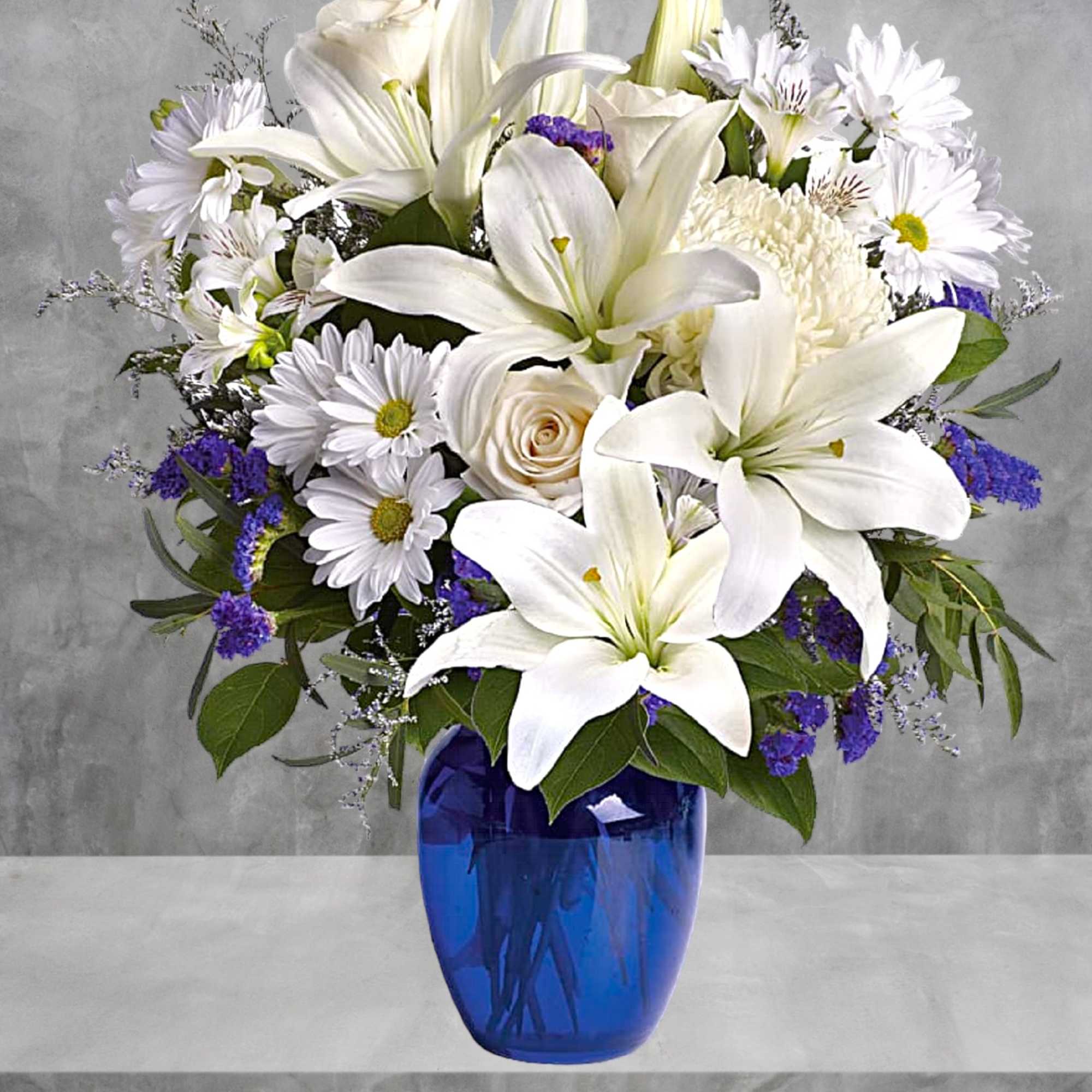 White lilies and daisies arranged in a blue vase, photo 3 of 4