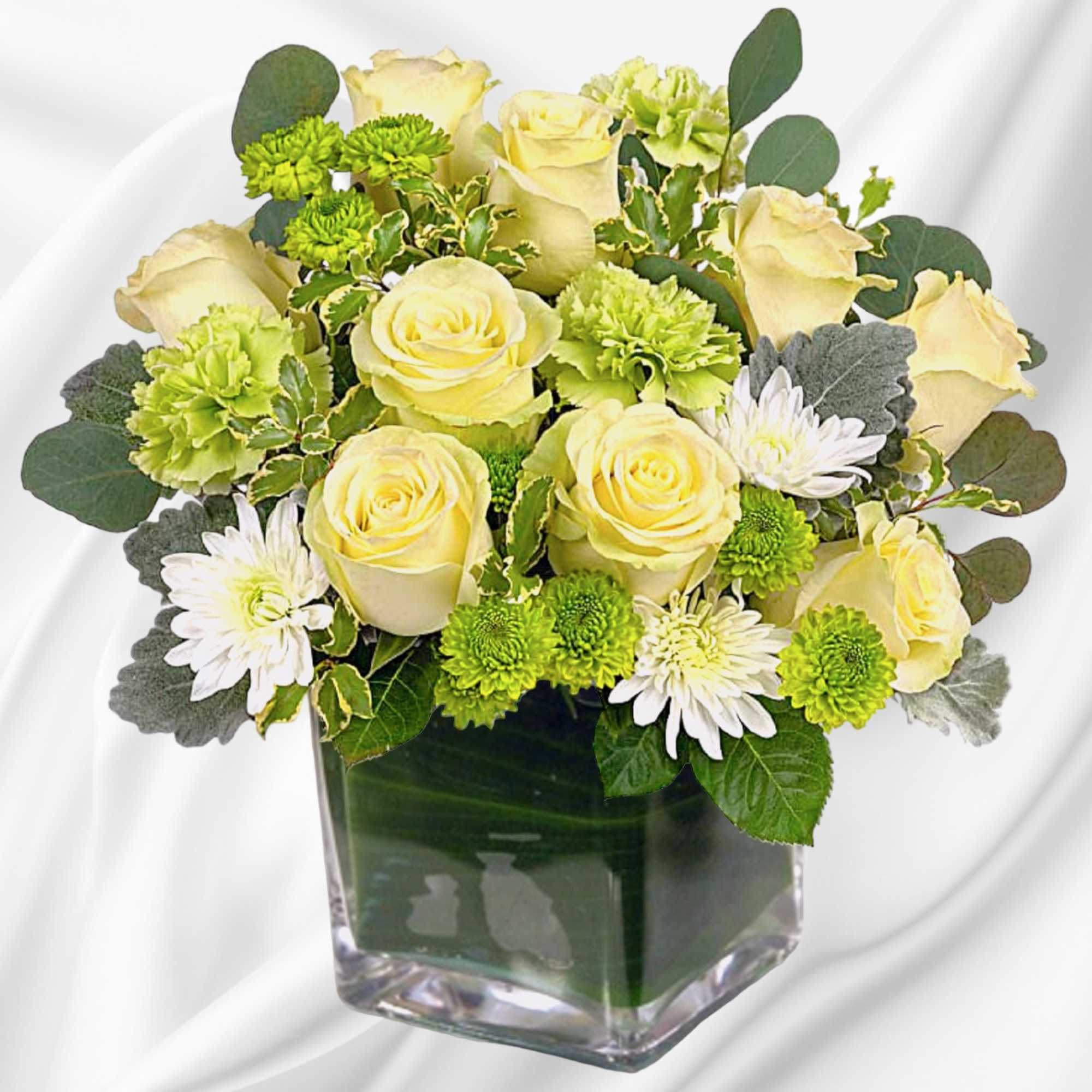 Yellow roses and green chrysanthemums in a clear square vase