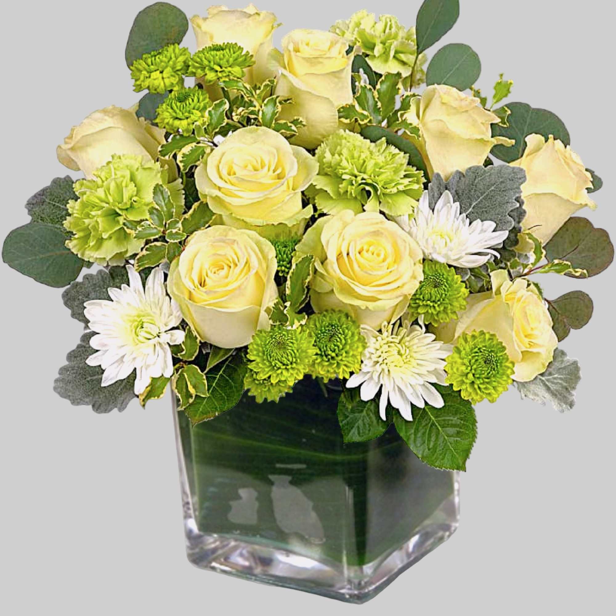 Yellow roses and green mums in a square glass vase