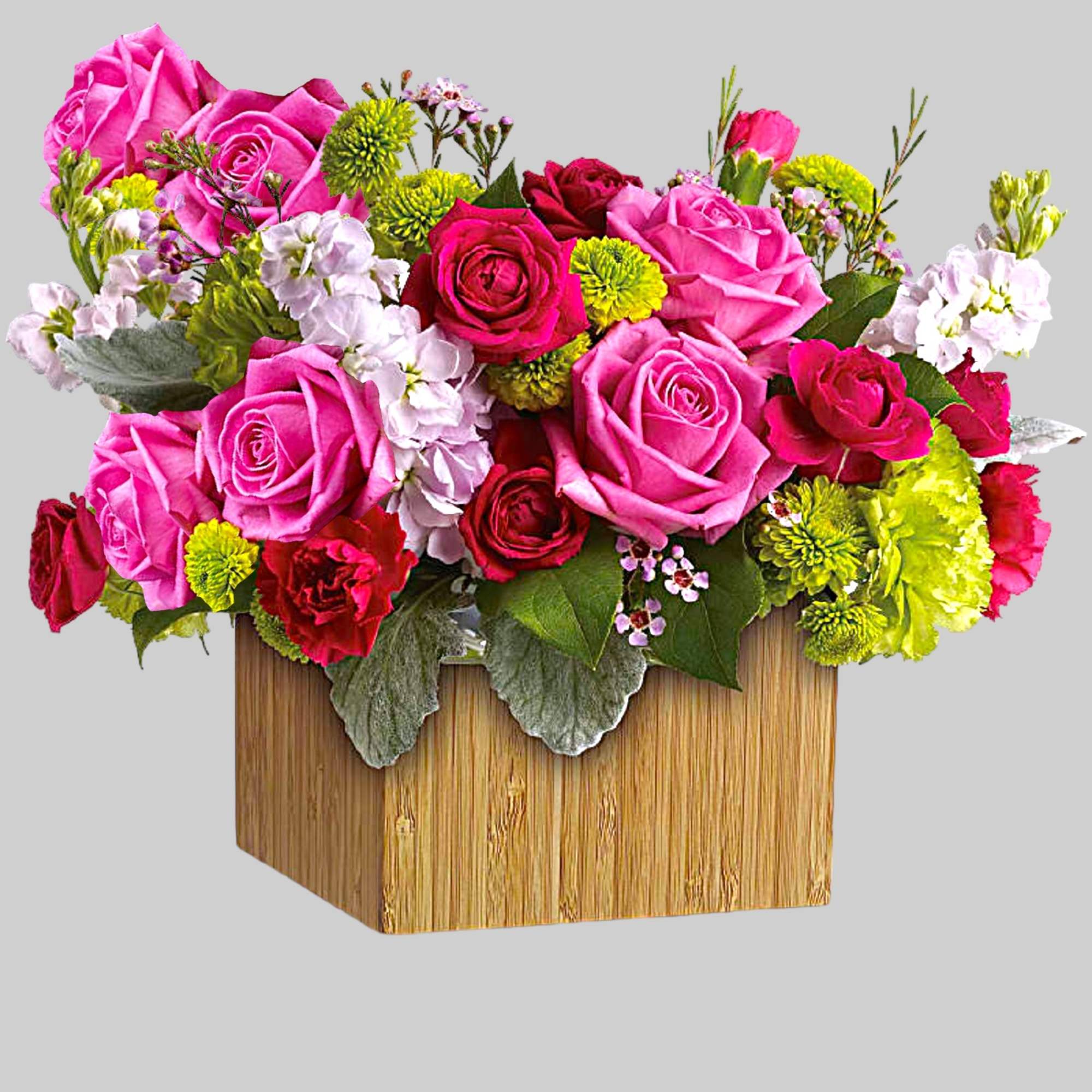 Pink and red roses in a wooden box with green and white accents