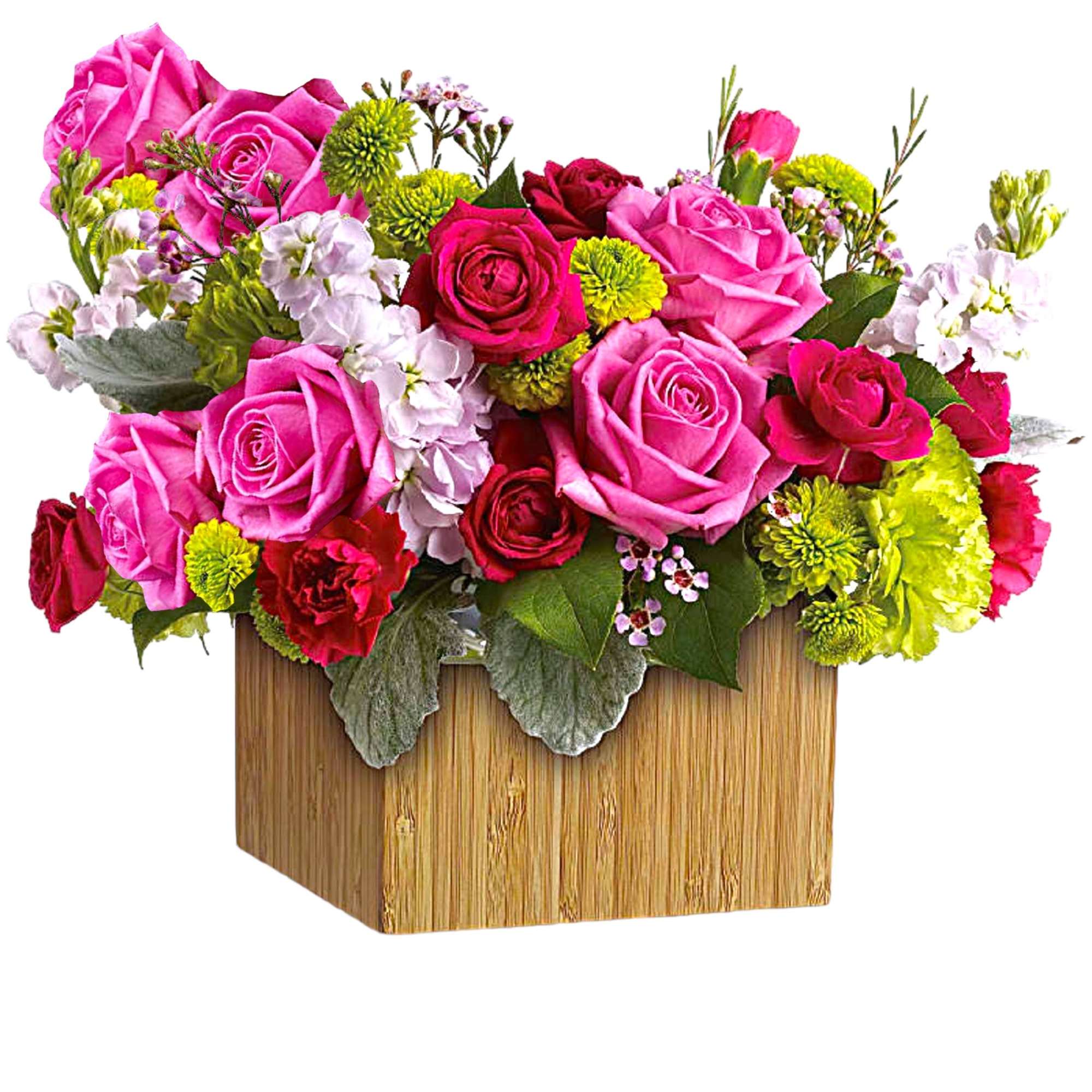 Pink and red roses arranged in a wooden box with green and white accents