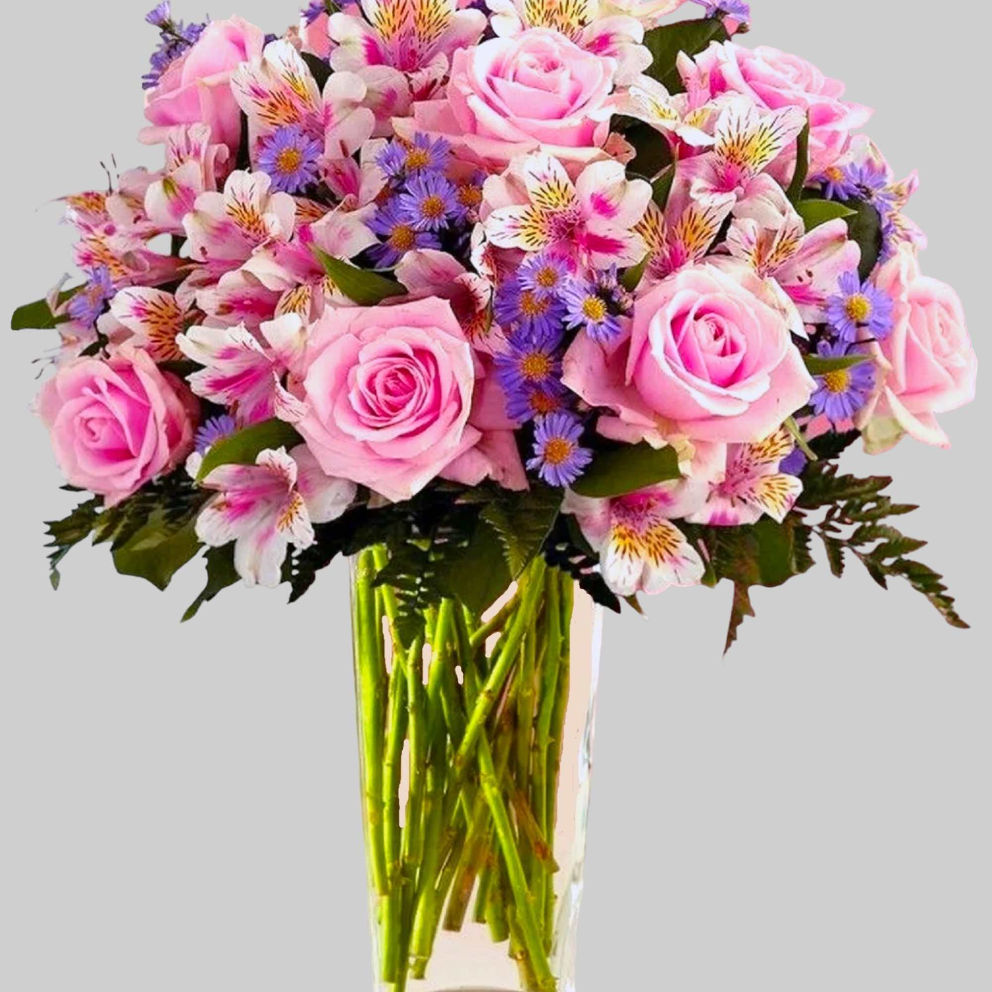 Pink roses and mixed daisies in a clear glass vase