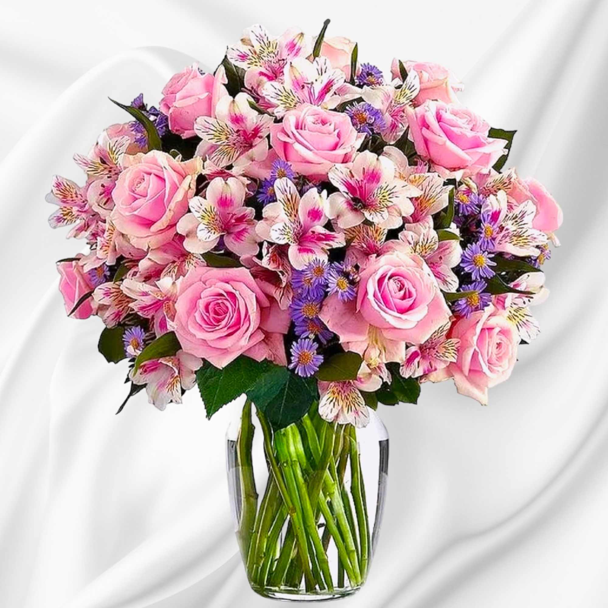 Pink roses and mixed blooms arranged in a clear glass vase, photo 2 of 6