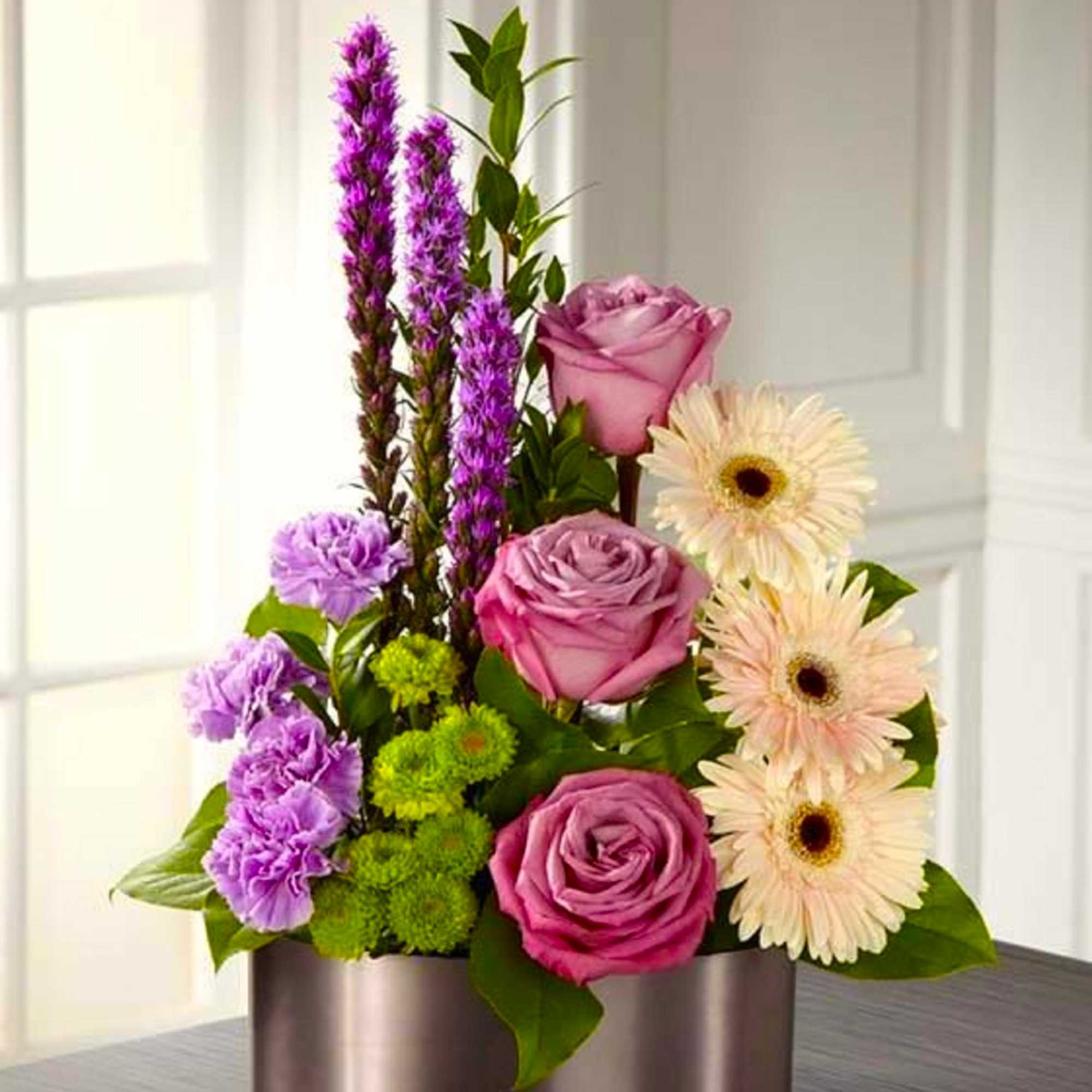 Pink roses and pale gerbera daisies in a round metal container
