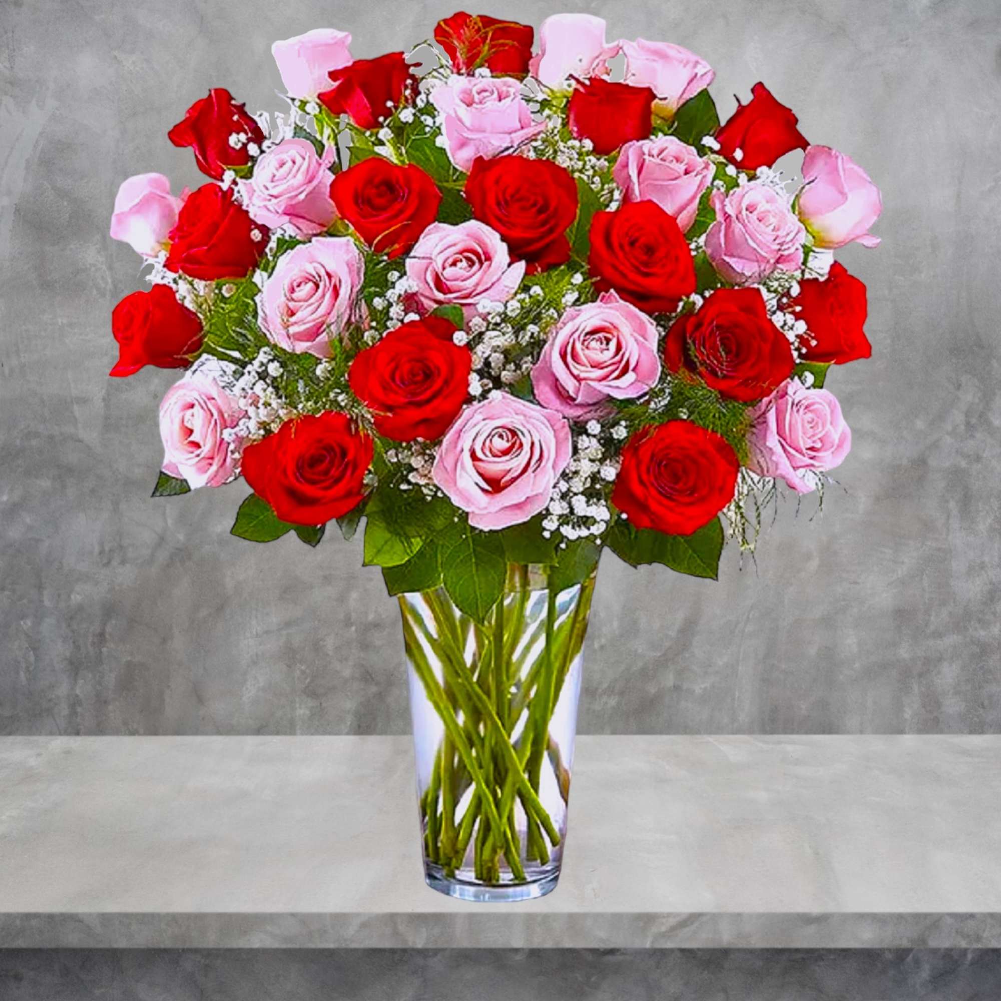 Red and pink roses arranged in a clear glass vase
