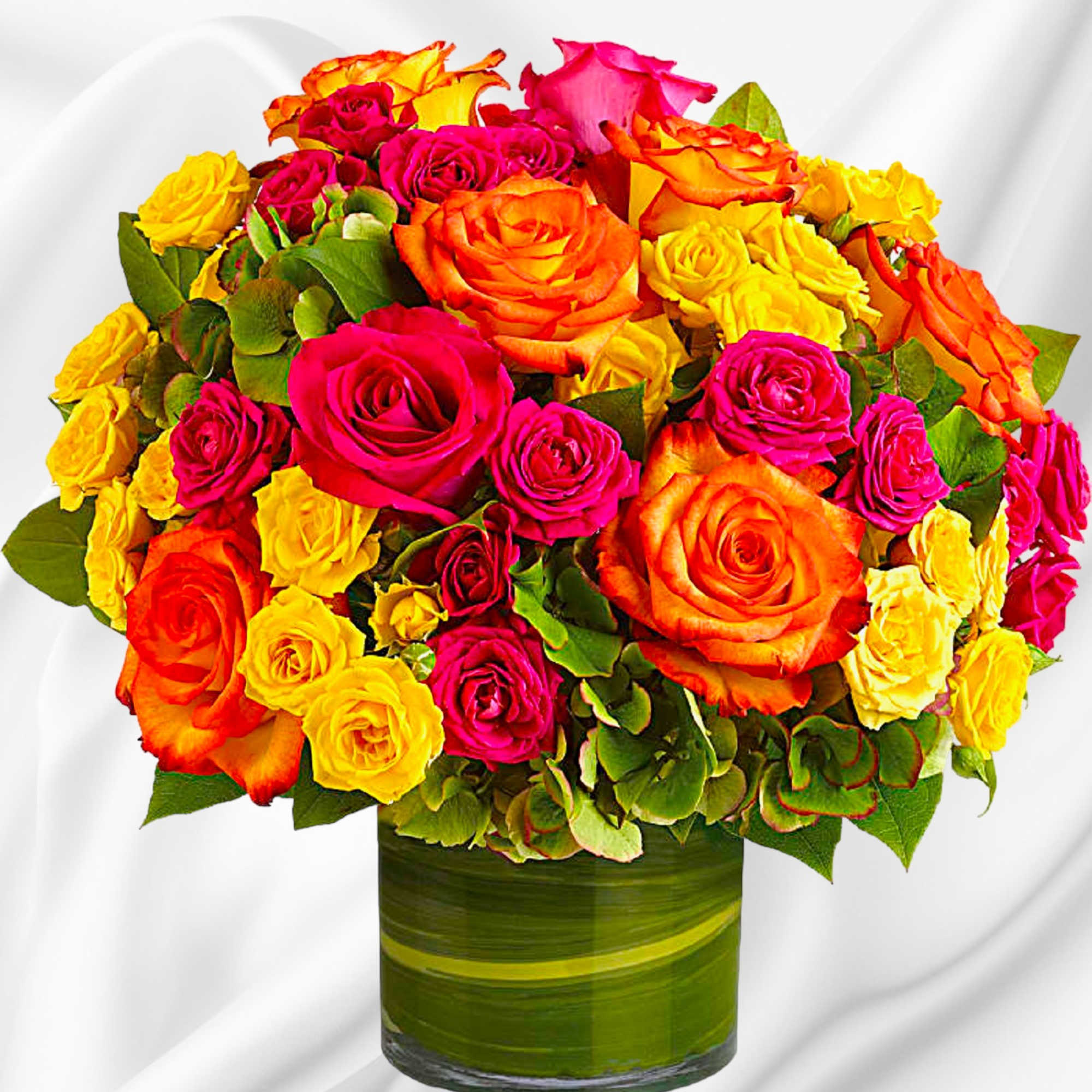 Mixed roses in pink, orange, and yellow arranged in a glass vase