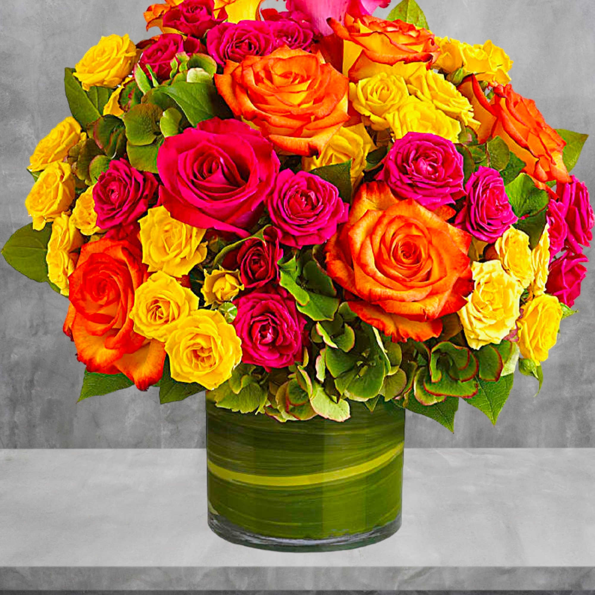 Bouquet of orange, pink, and yellow roses in a green glass vase