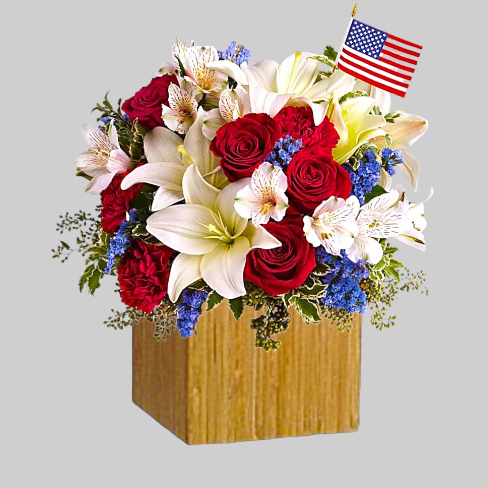 Red roses and white lilies in a wooden box with a small American flag