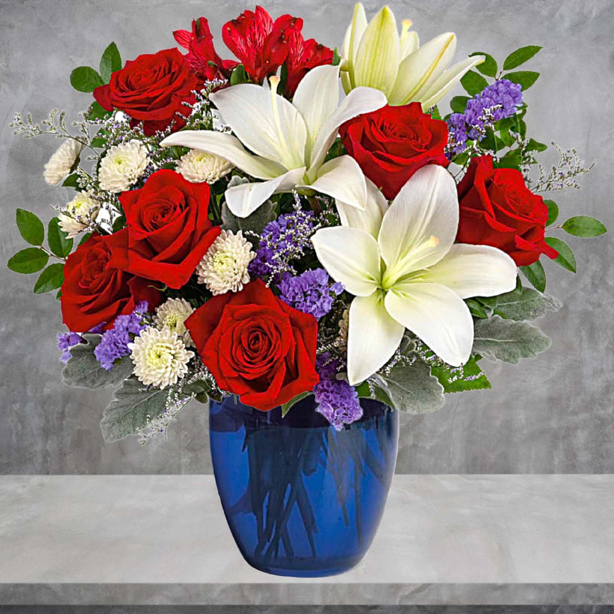Red roses and white lilies arranged in a blue glass vase, photo 3 of 4