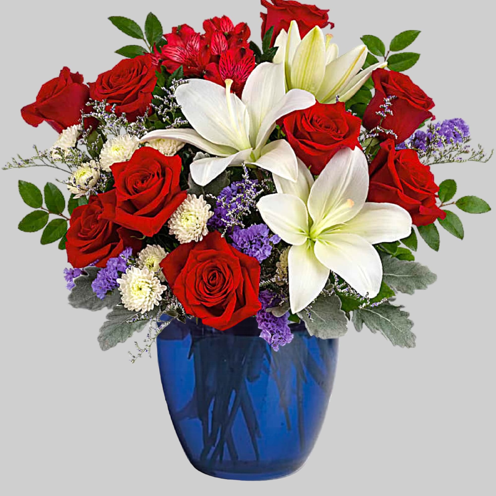 Red roses and white lilies arranged in a blue glass vase