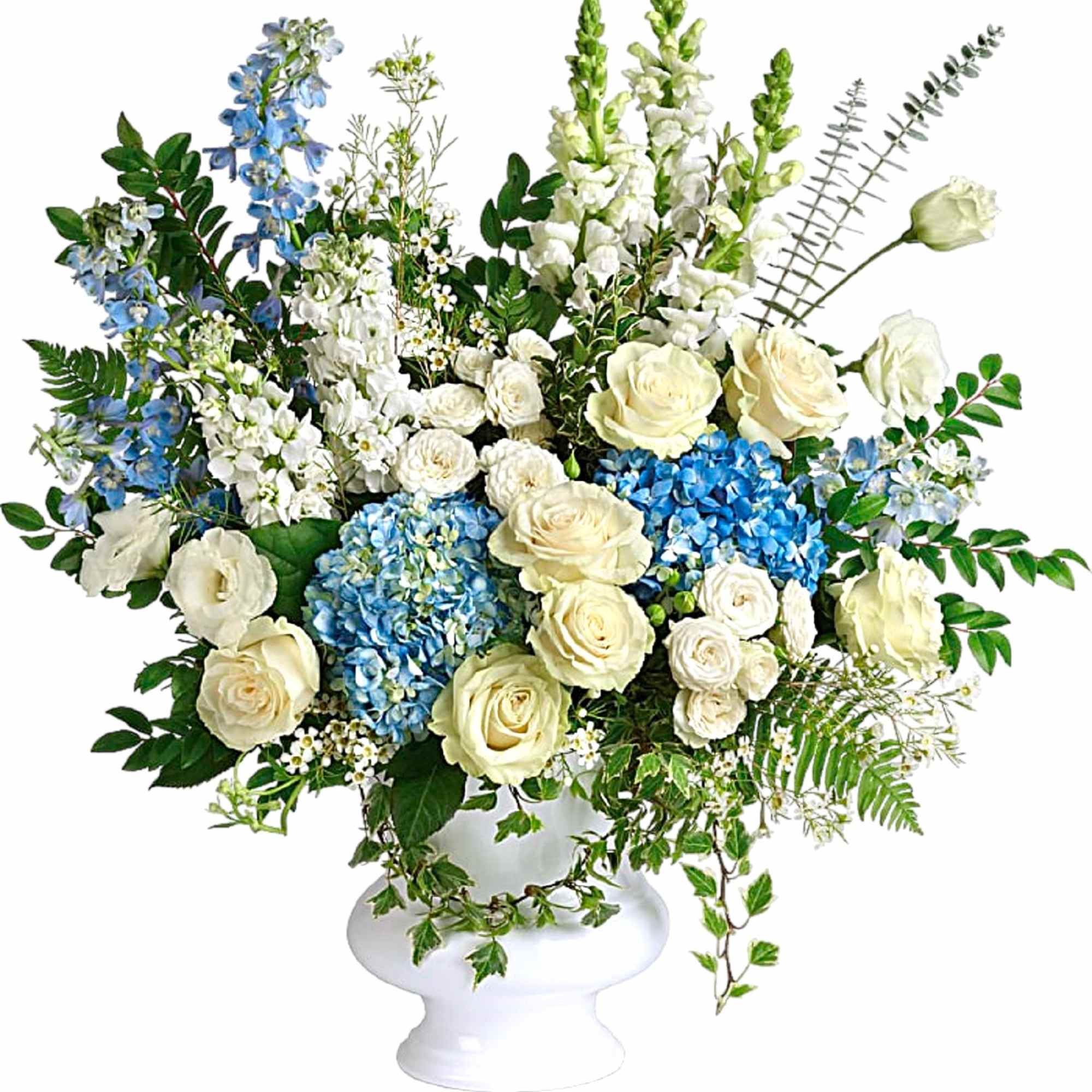 White and blue floral arrangement in a white pedestal vase