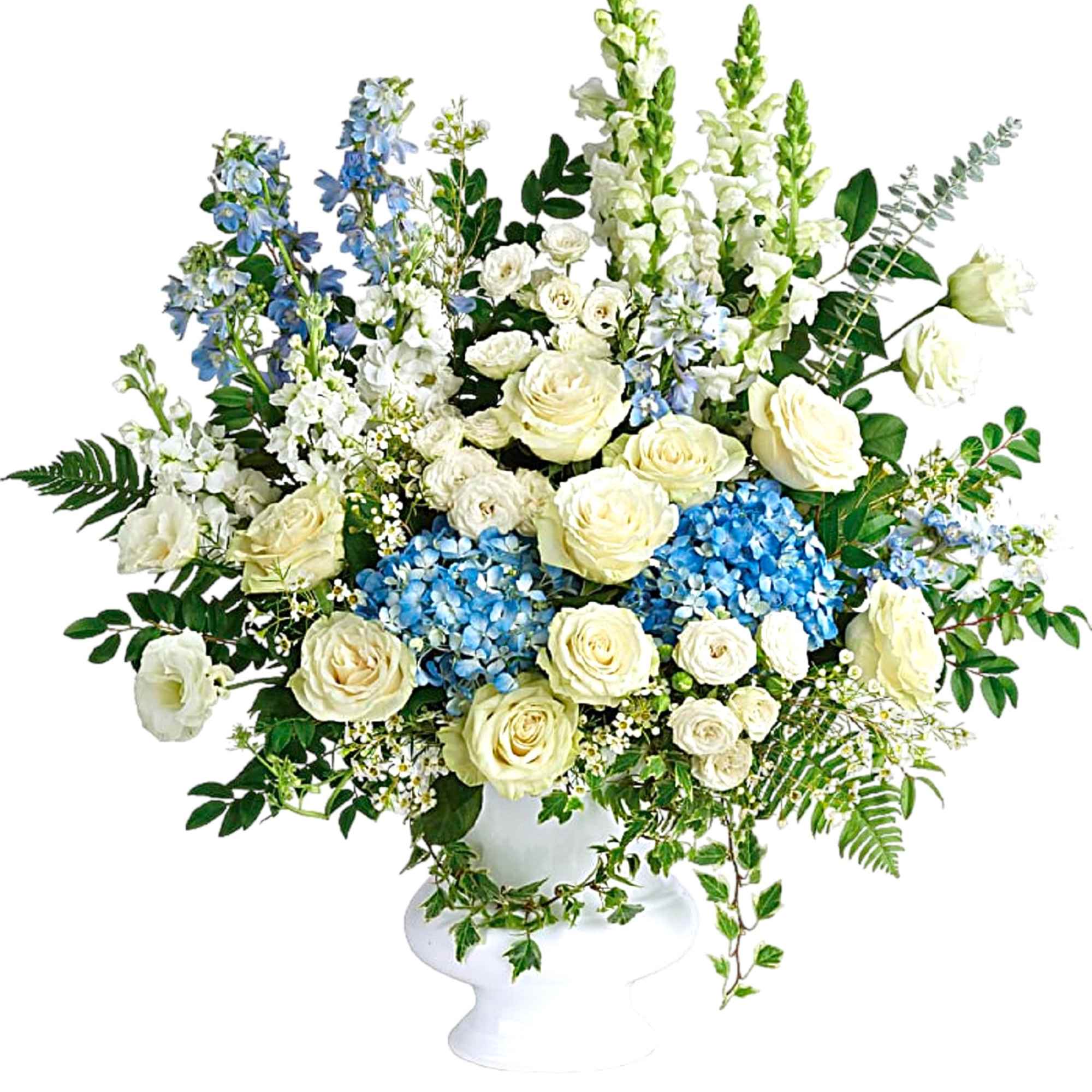 White and blue floral arrangement in a white pedestal vase