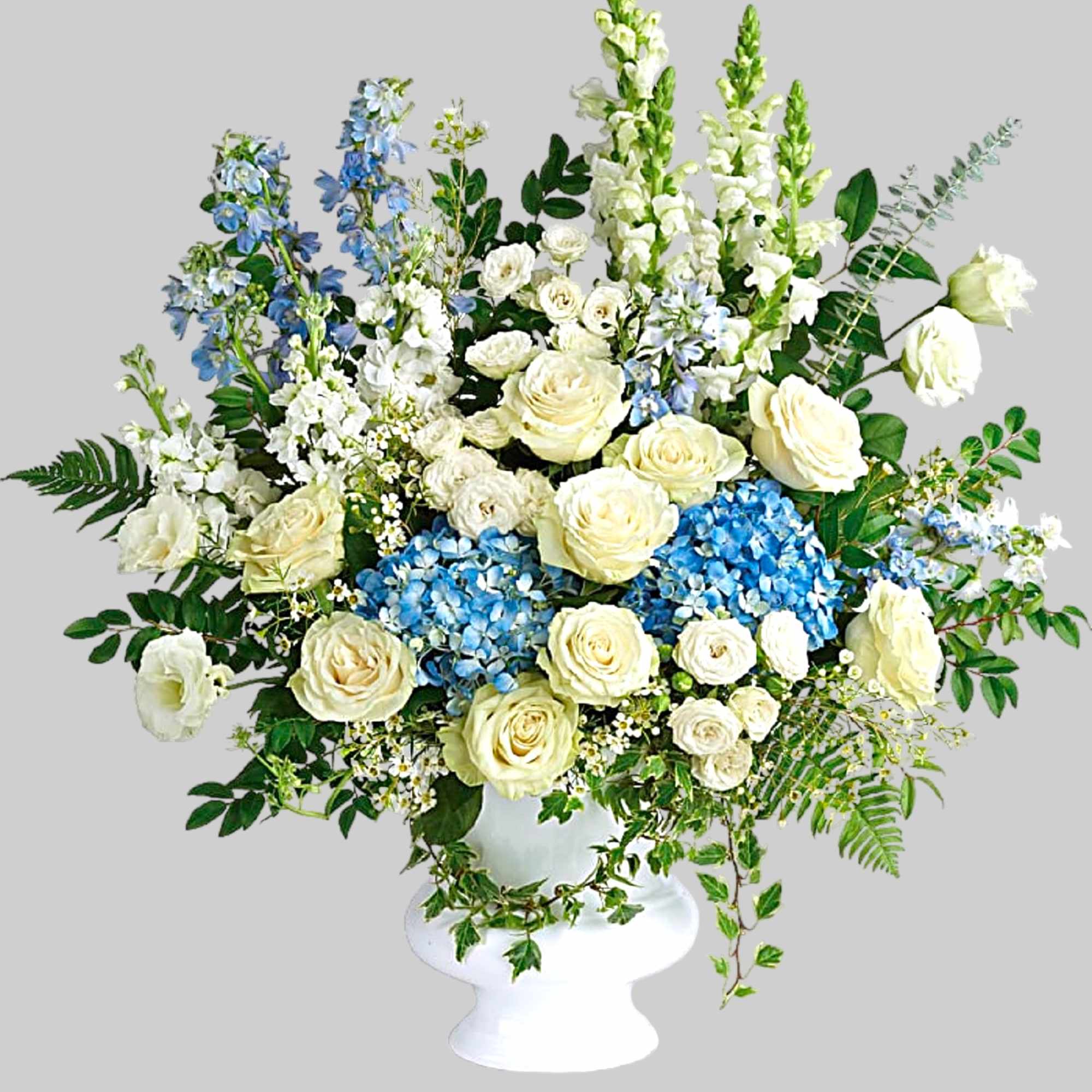 White roses and blue flowers arranged in a white pedestal vase, photo 4 of 4