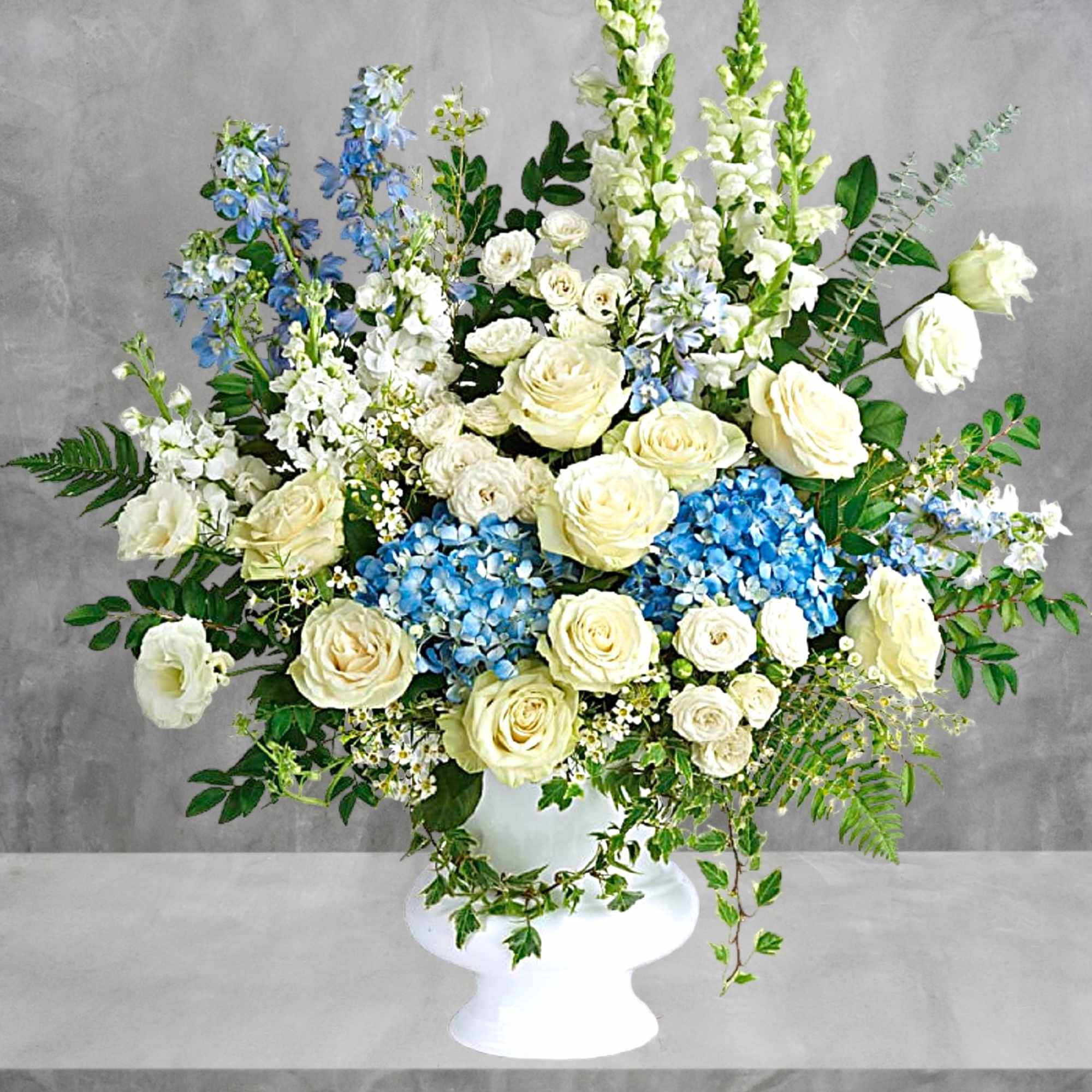 White and blue floral arrangement in a white pedestal vase, photo 3 of 4