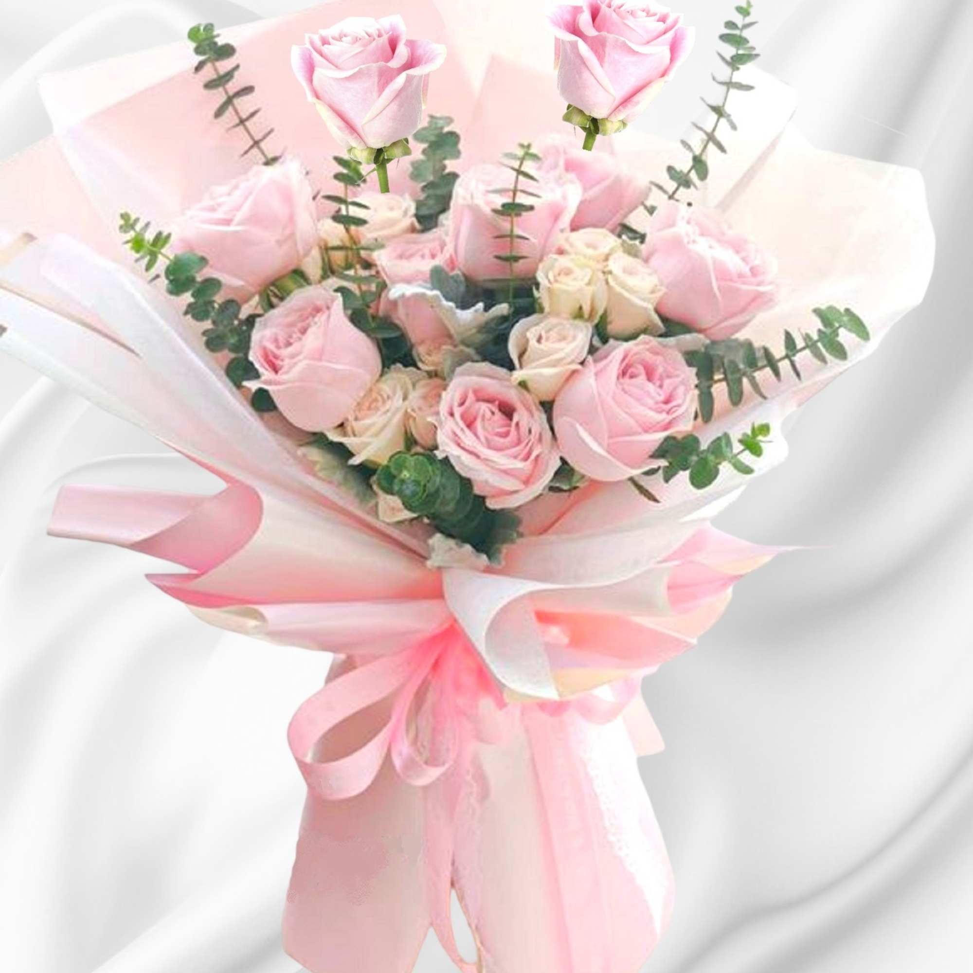 Pink roses wrapped in pale pink paper with a ribbon bow