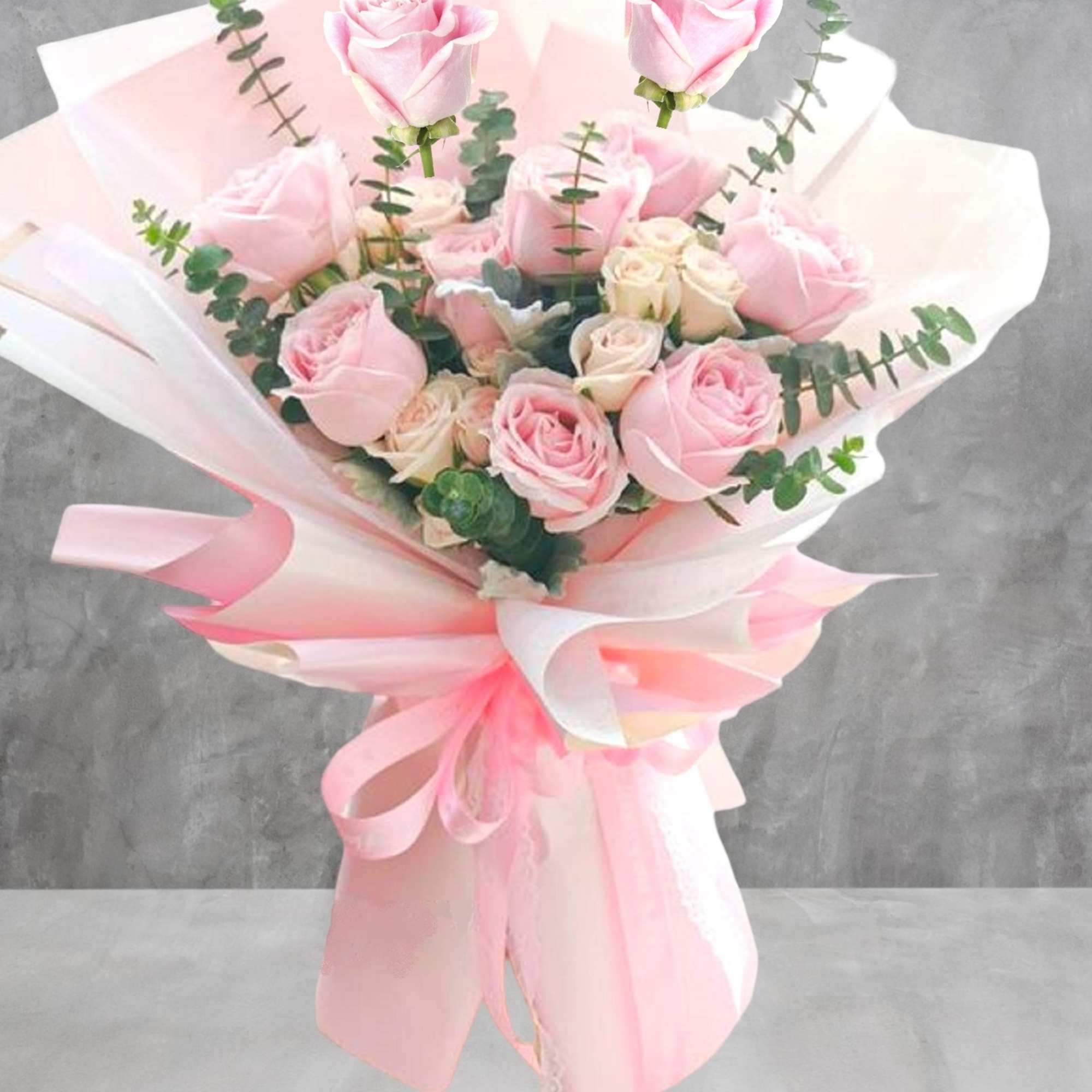 Bouquet of pale pink roses wrapped in pink and white paper