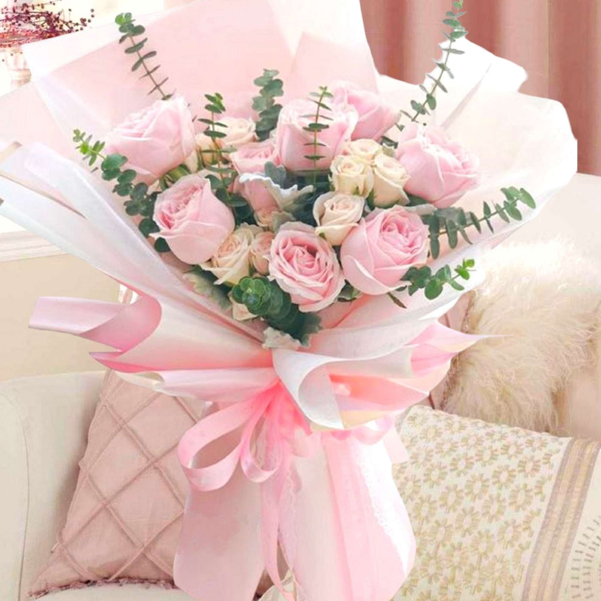 Bouquet of pale pink roses wrapped in white and pink paper