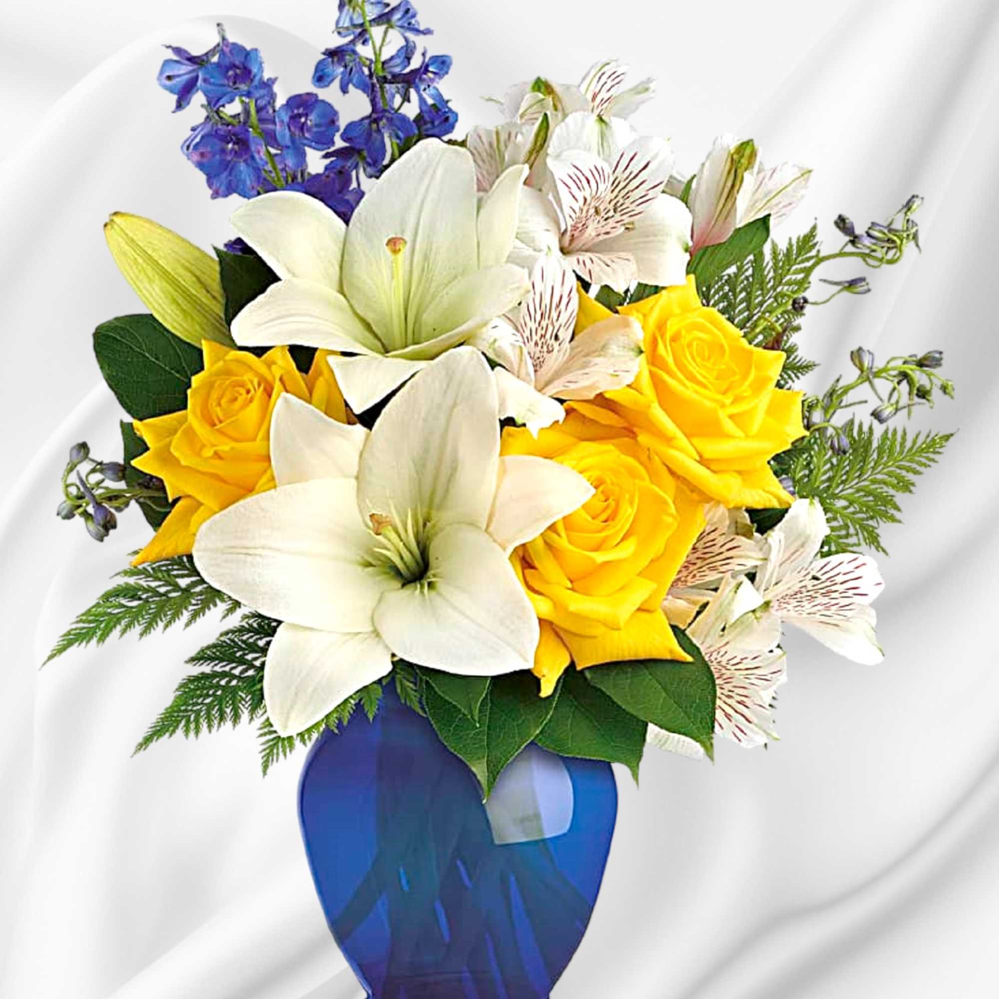 Yellow roses and white lilies in a blue vase
