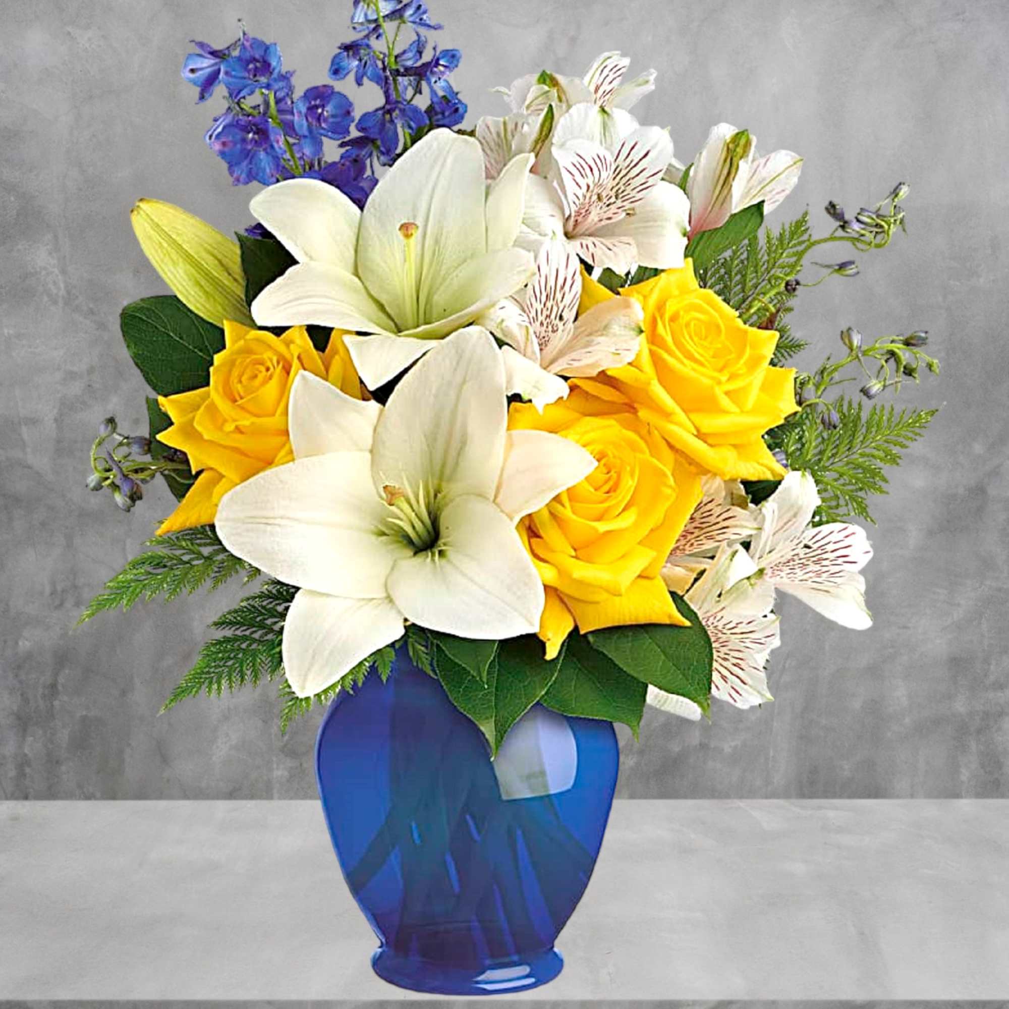 Yellow roses and white lilies in a blue vase with blue flowers, photo 3 of 4