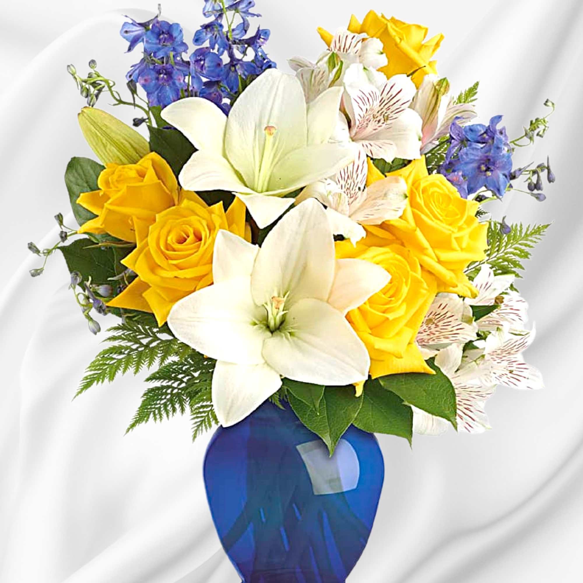 Yellow roses and white lilies in a blue vase