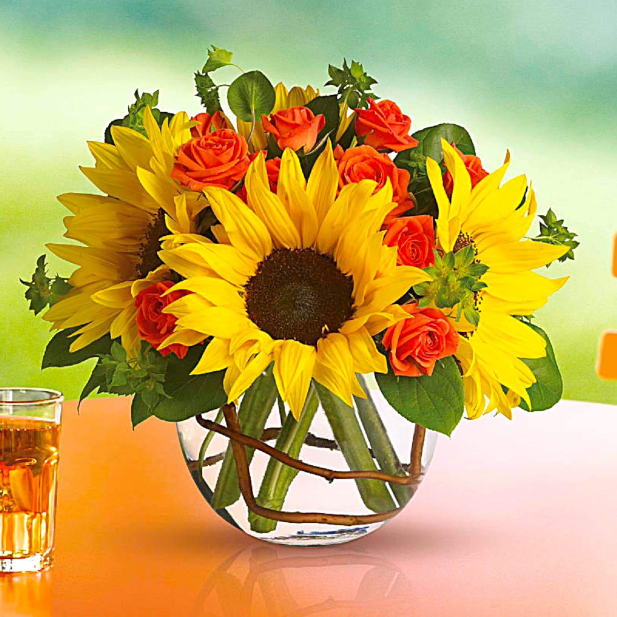 Sunflowers and orange roses in a clear glass vase, photo 2 of 6