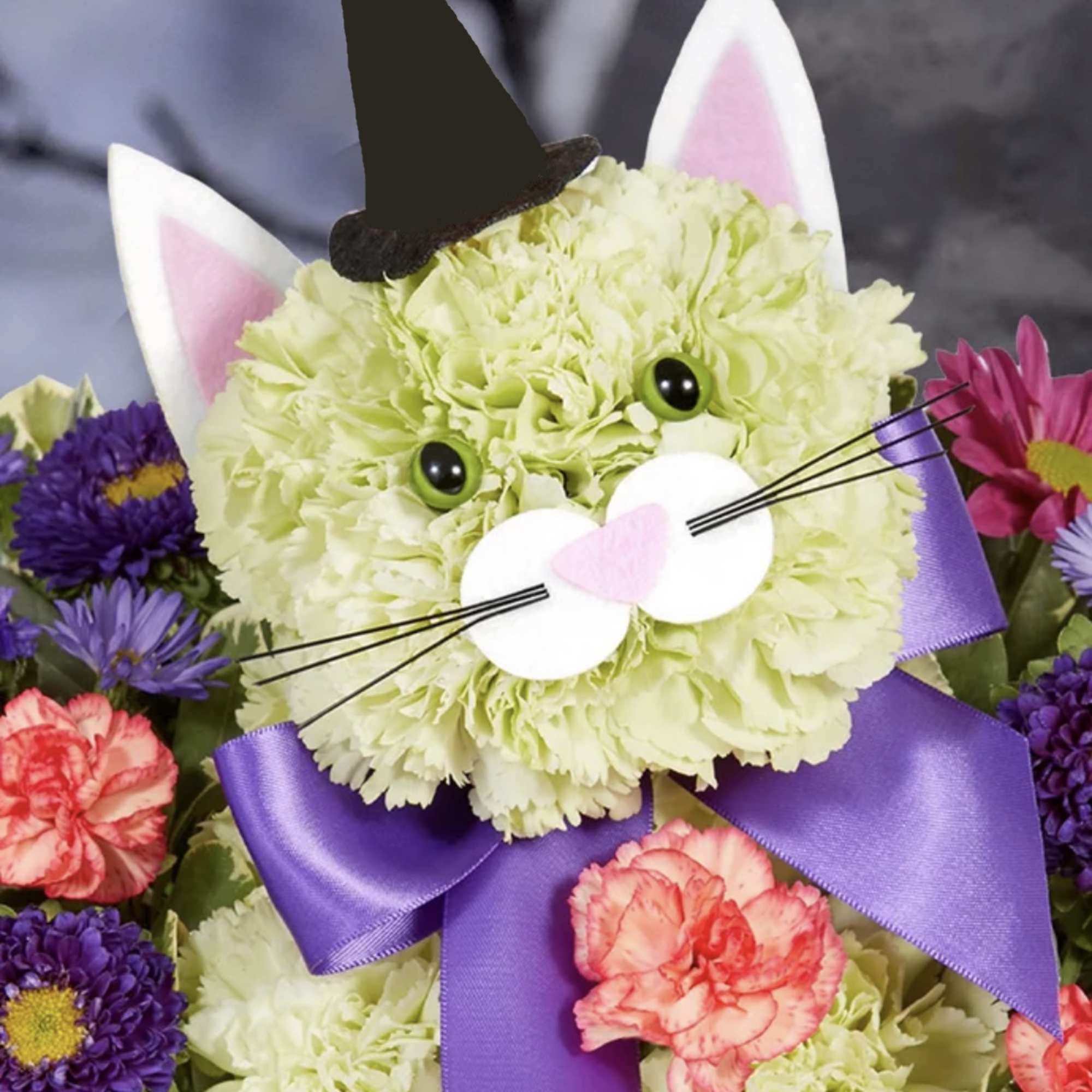 Cat-themed floral arrangement with a purple ribbon and bunny ears