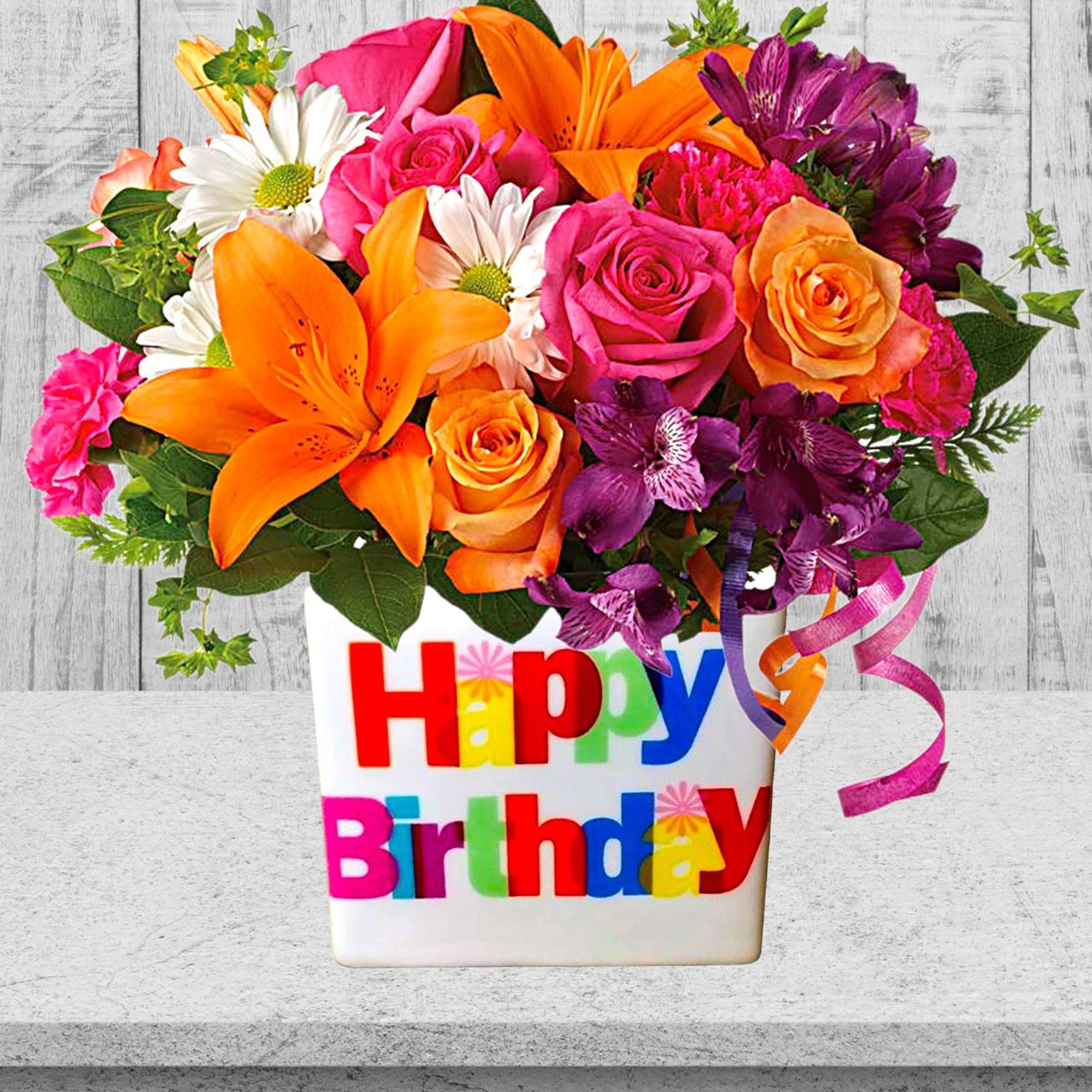 Colorful mixed flower arrangement in a Happy Birthday vase