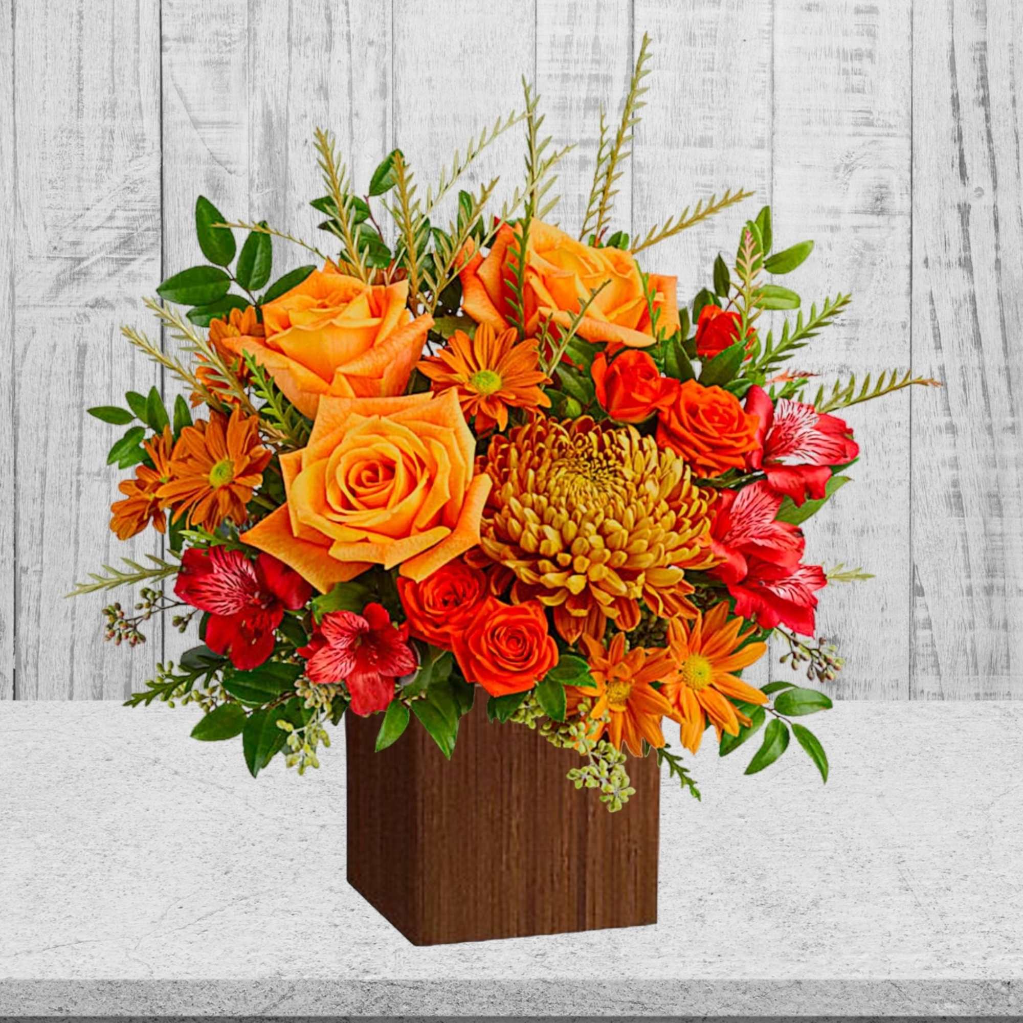 Orange and red floral arrangement in a wooden cube vase, photo 3 of 3