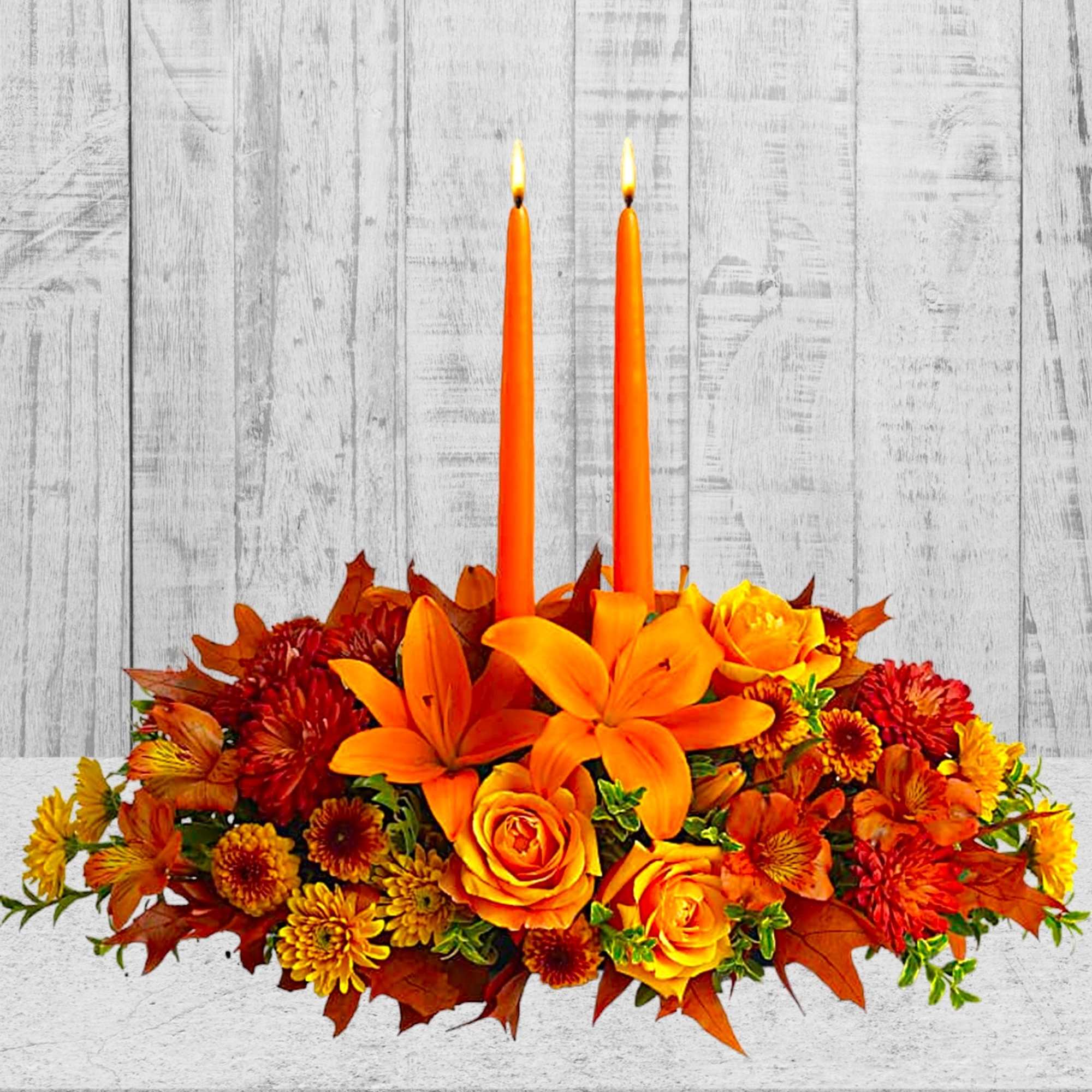 Orange floral centerpiece with two lit taper candles, photo 2 of 4