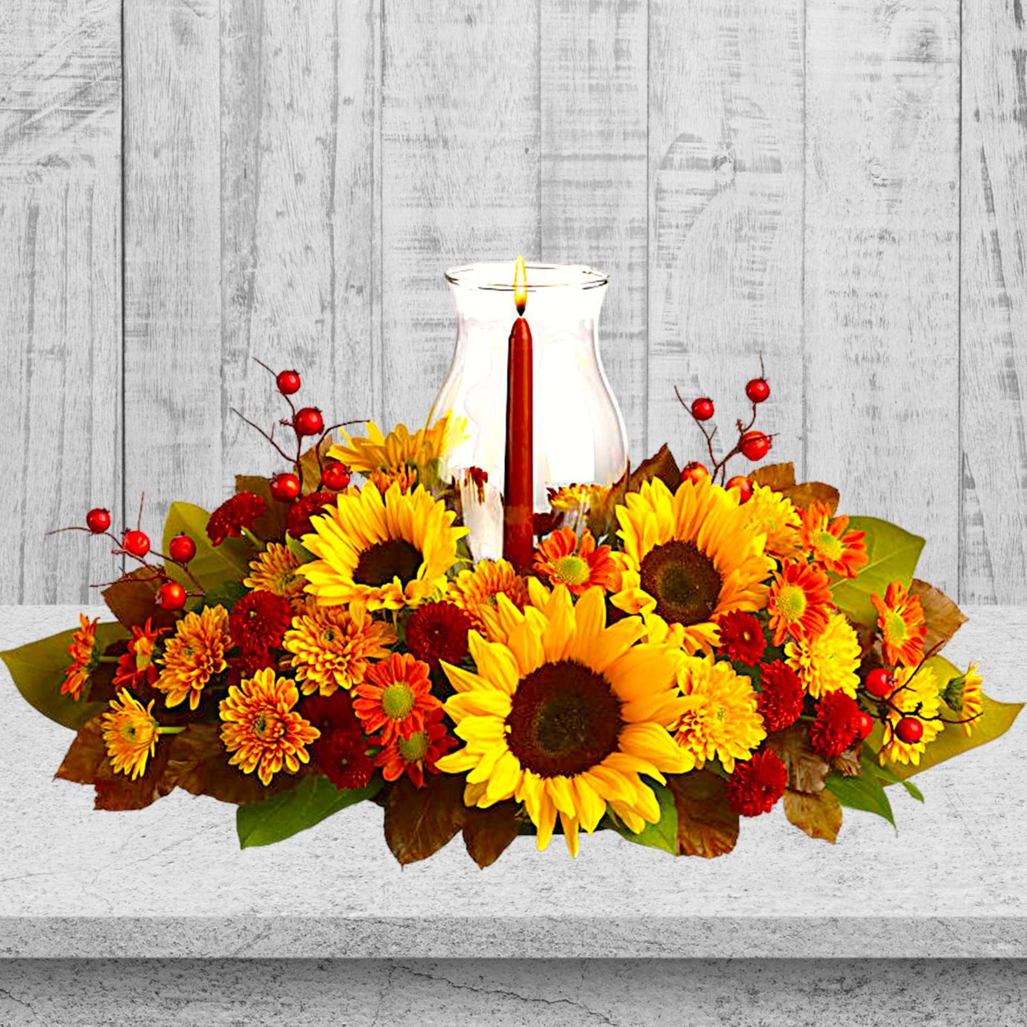 Sunflower and chrysanthemum centerpiece with a glass candle holder