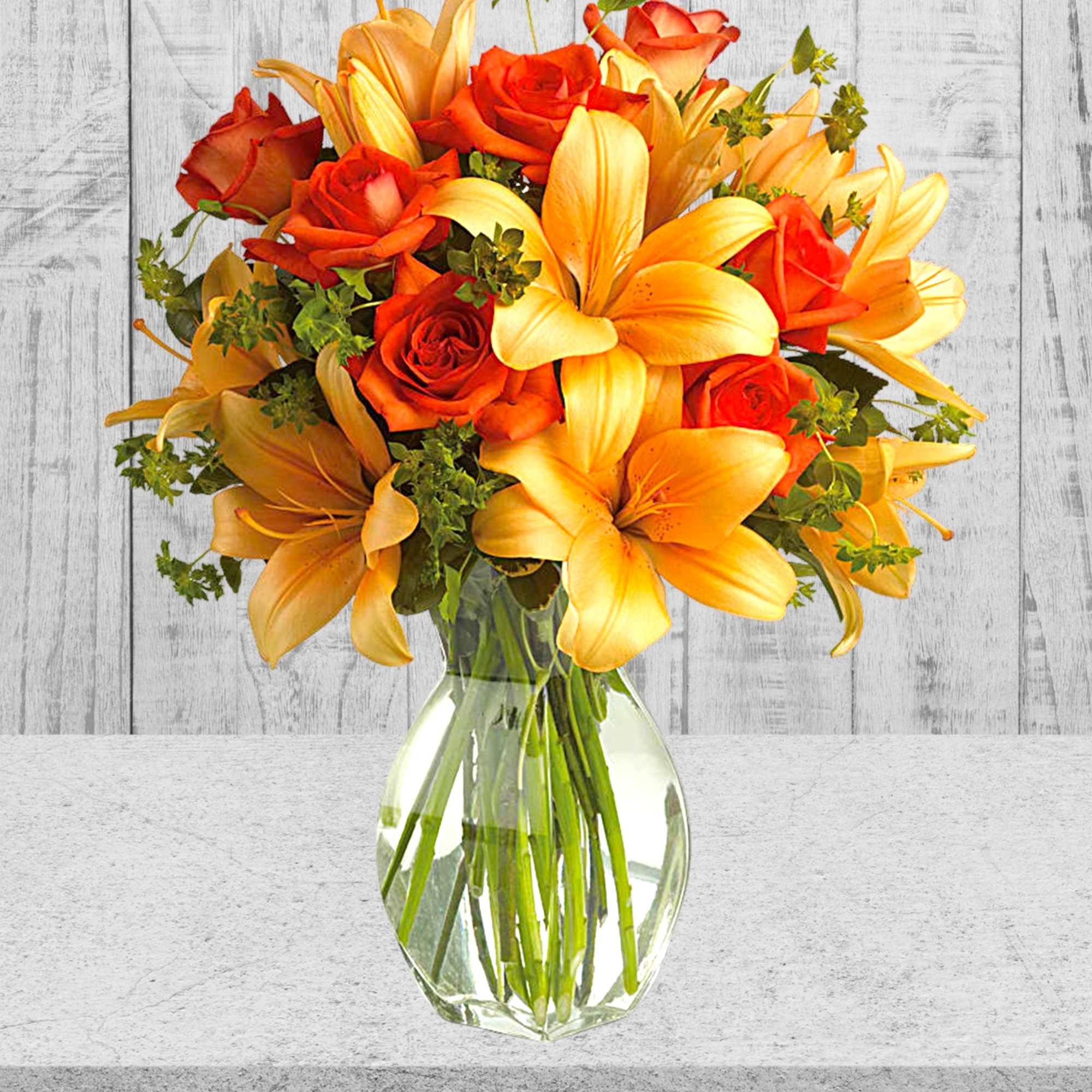 Bouquet of orange roses and yellow lilies in a clear glass vase, photo 3 of 3