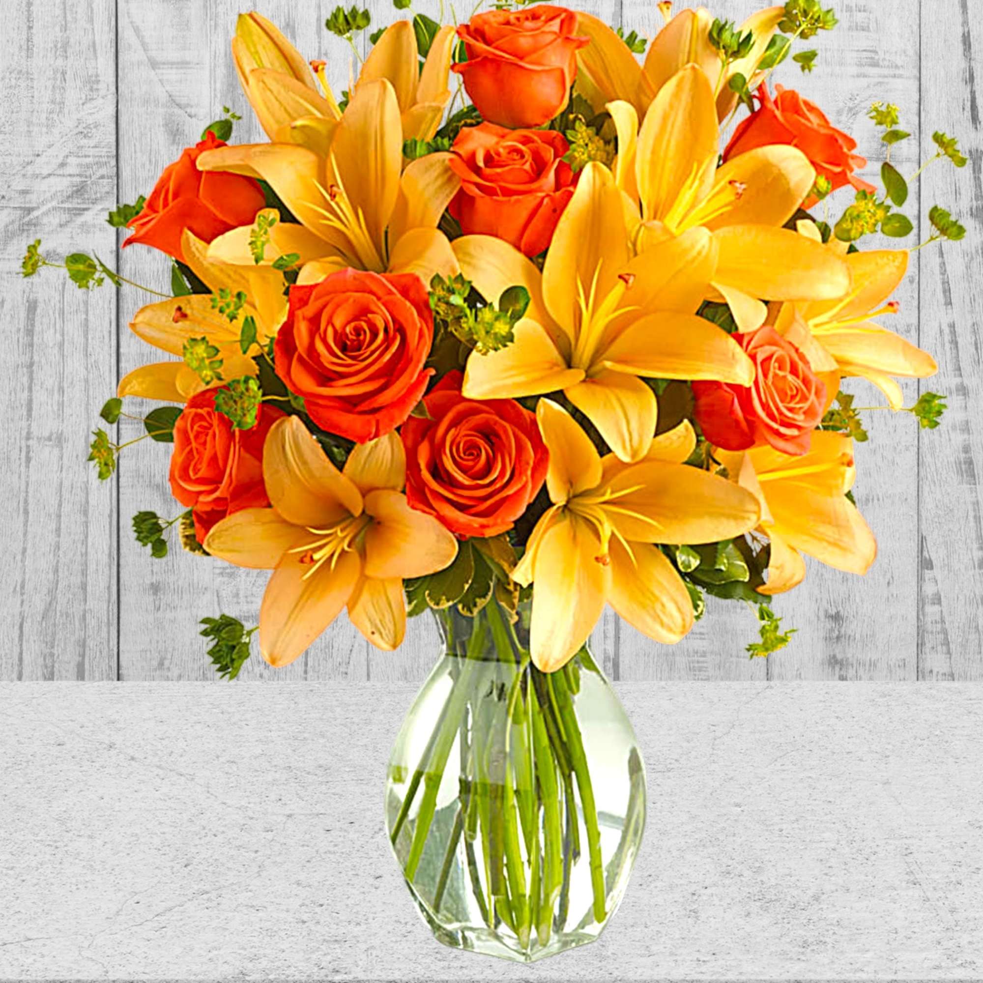 Orange roses and yellow lilies in a clear glass vase, photo 2 of 3