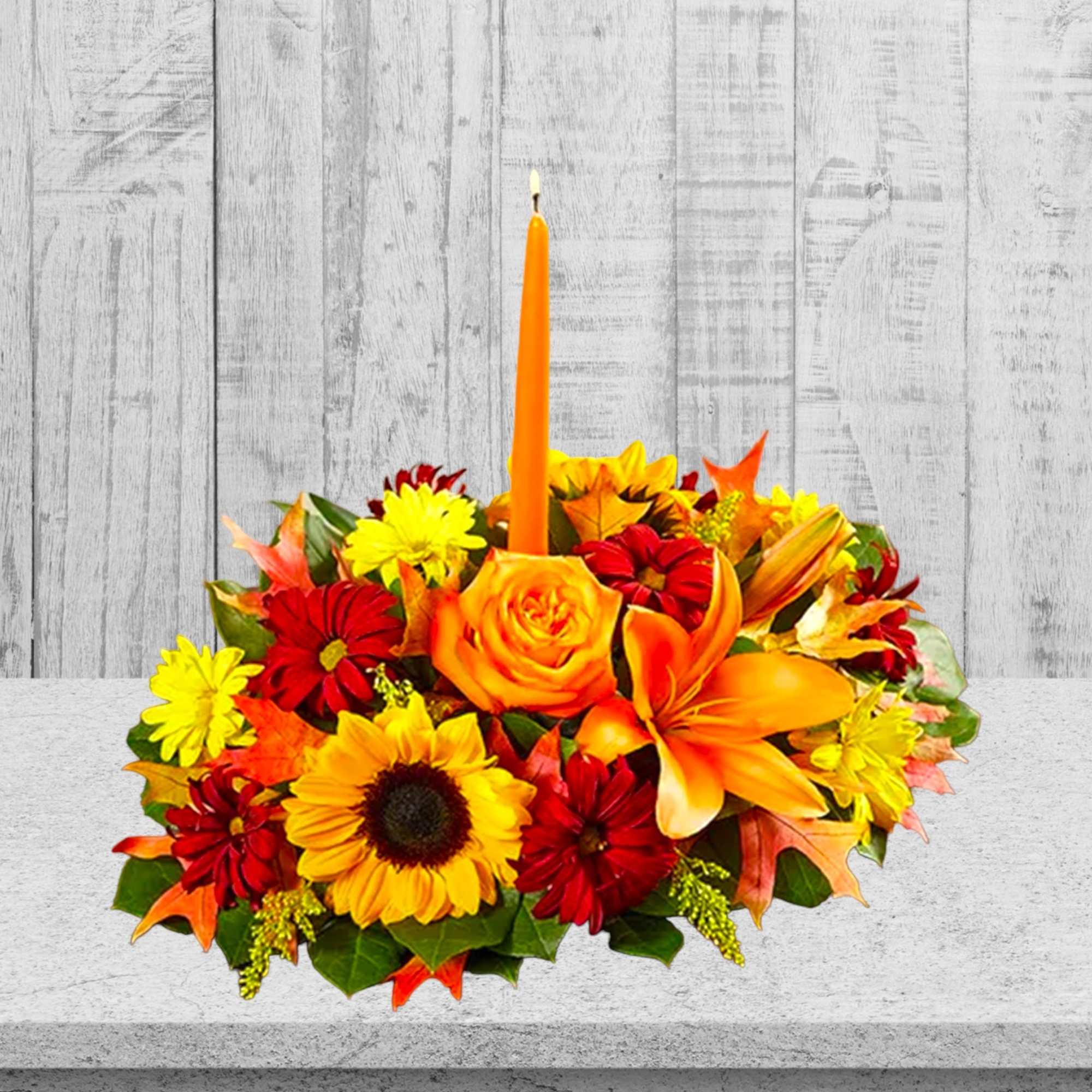 Autumn floral centerpiece with orange candle and mixed blooms