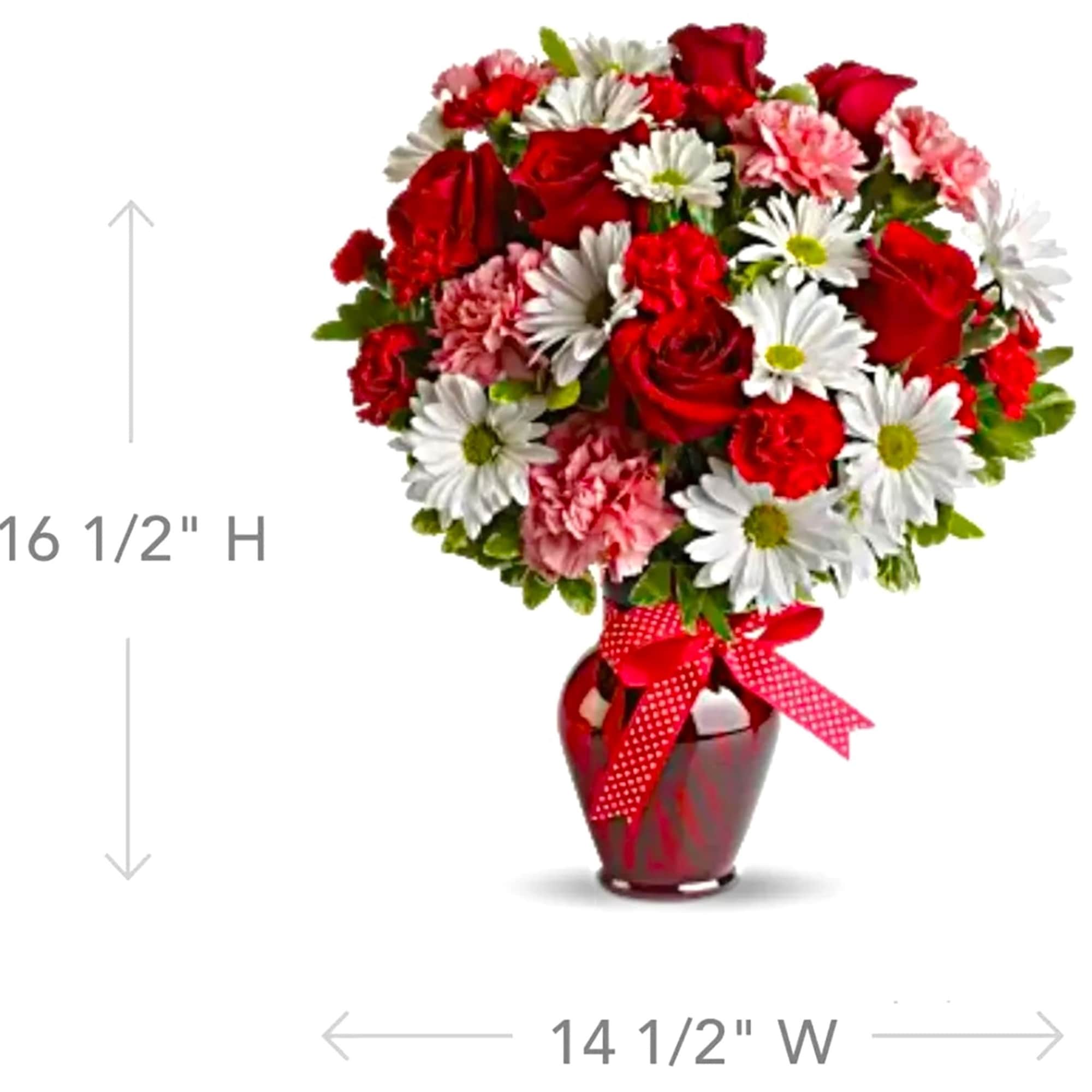 Red and white bouquet in a red vase with a ribbon