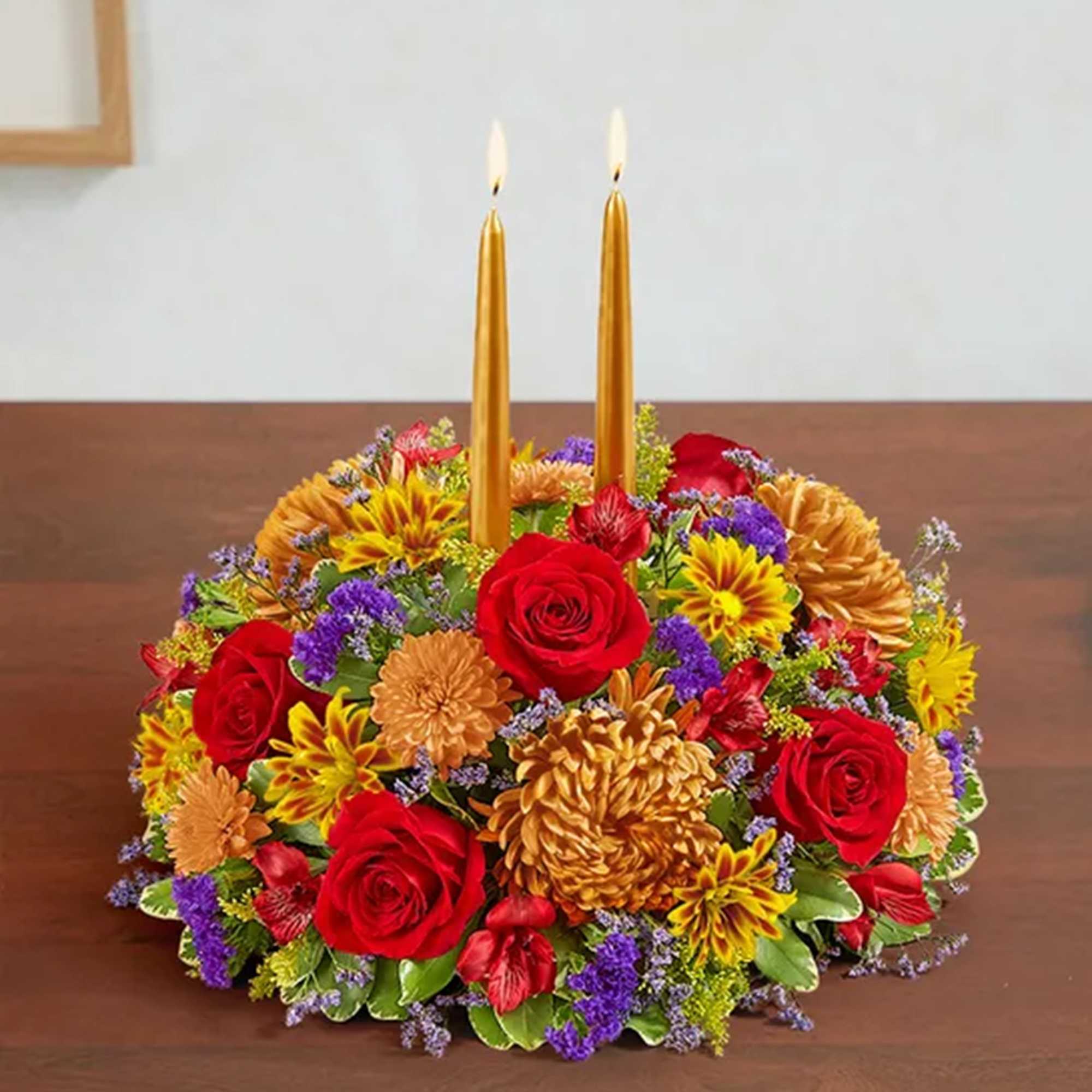 Floral centerpiece with red roses and gold candles