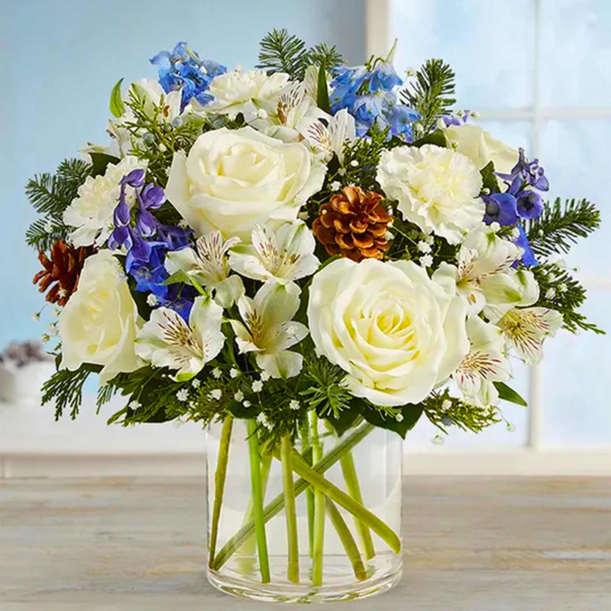 White roses and blue flowers arranged in a clear glass vase, photo 3 of 4