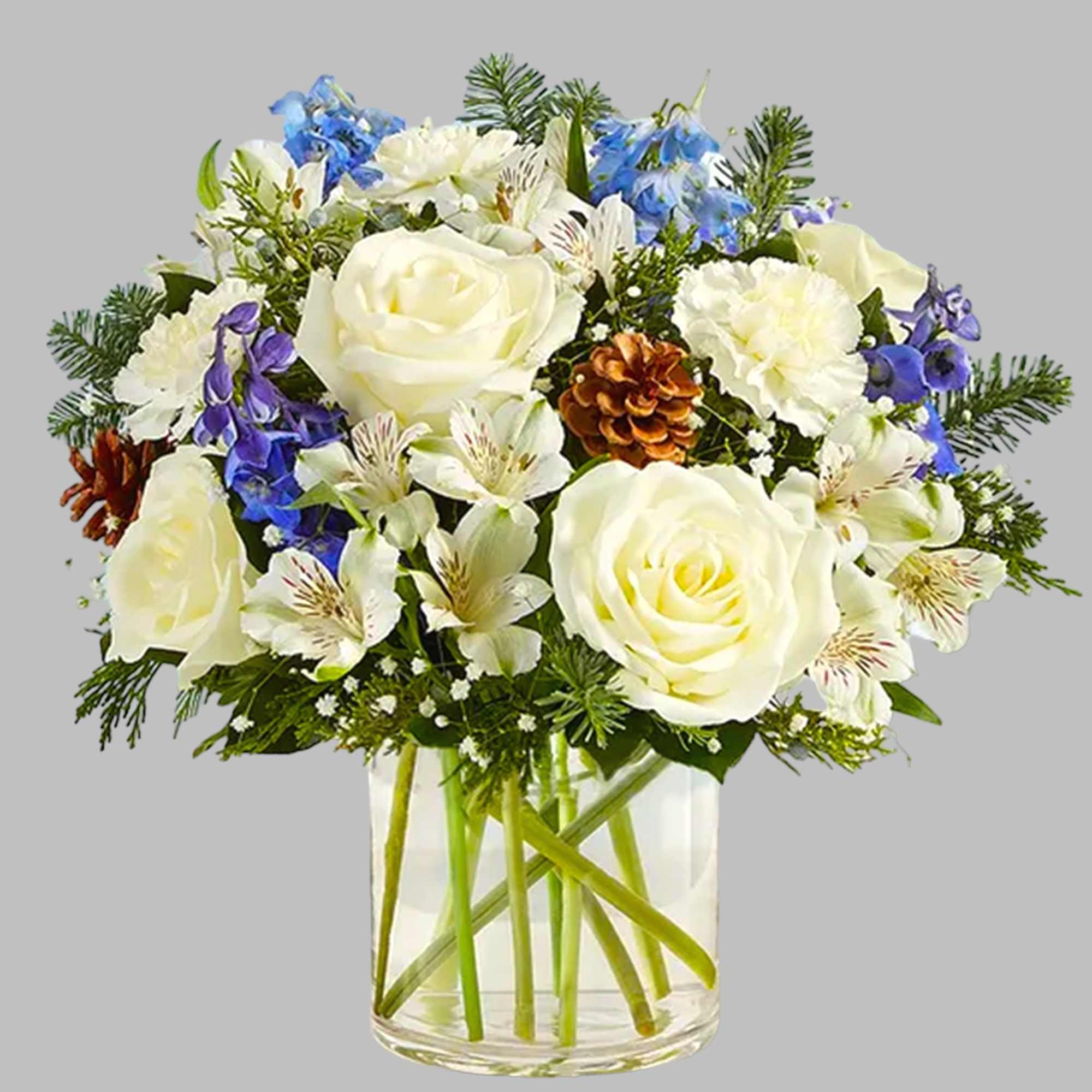 White roses and blue flowers in a clear glass vase