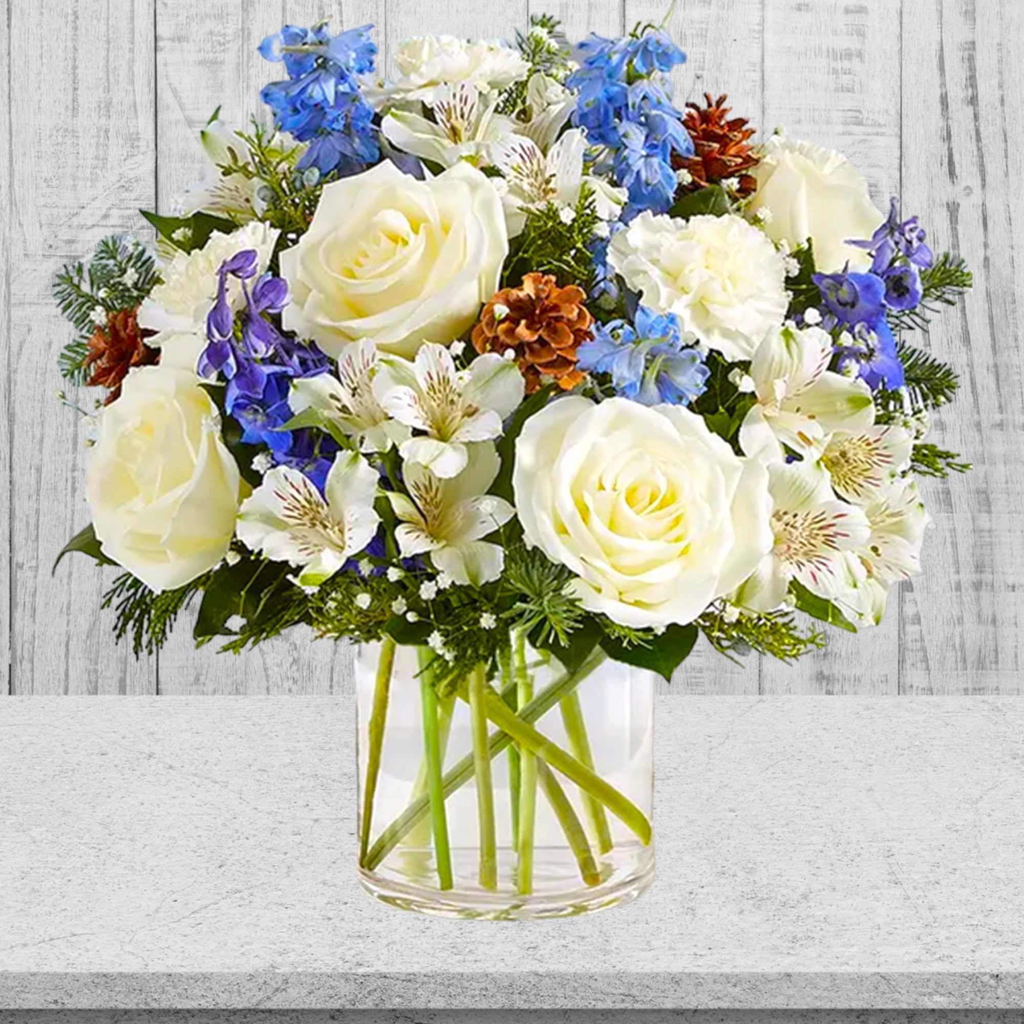 White roses and blue flowers in a clear glass vase, photo 3 of 4