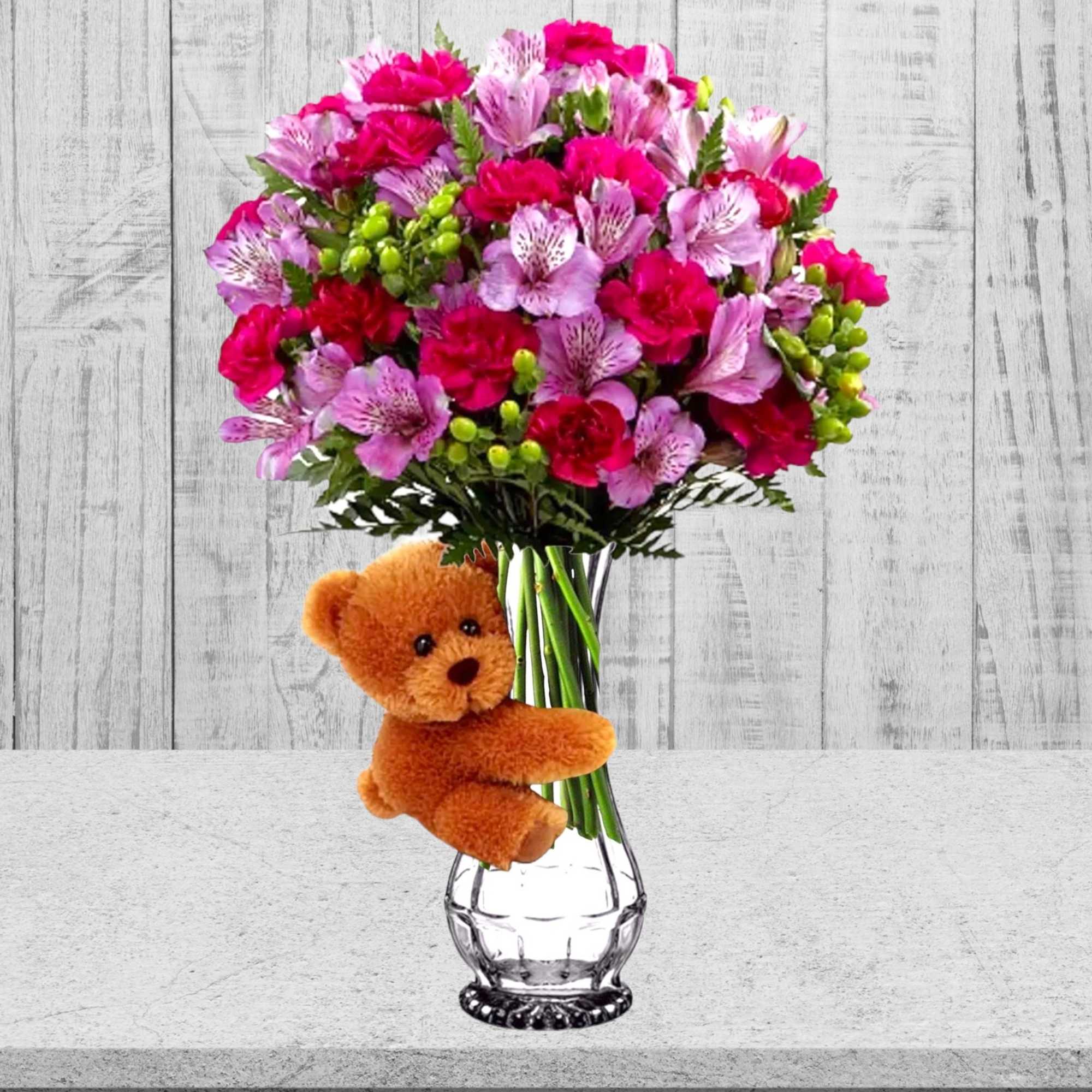Pink and red bouquet in a clear vase with a teddy bear attached, photo 2 of 3